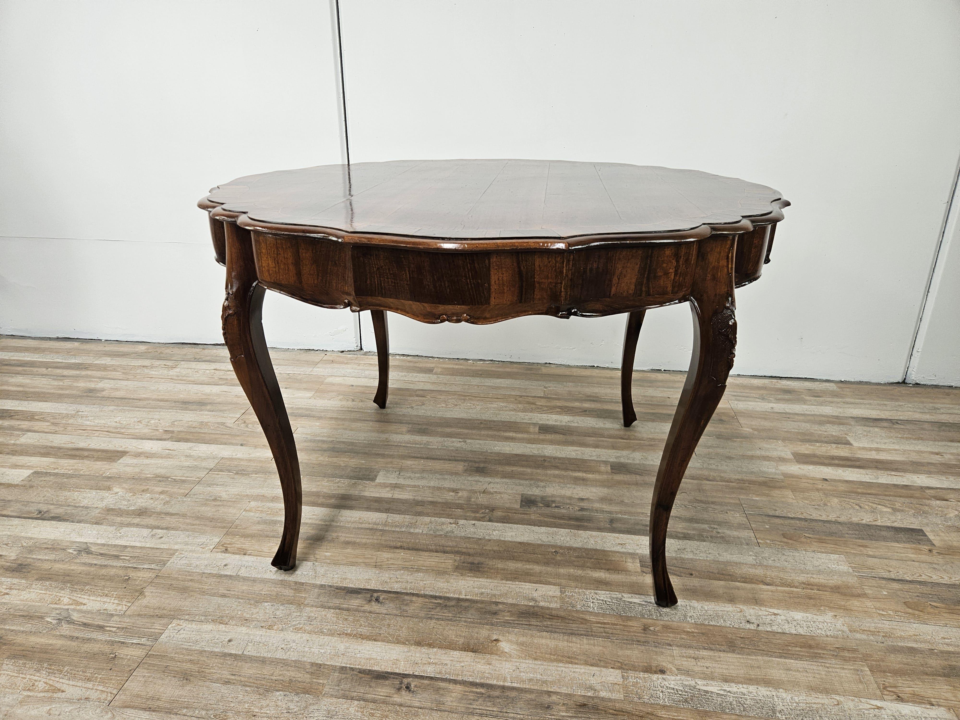 Early 20th-century Baroque-style round walnut table with maple decorations on the top and carvings along the four legs.

Ideal for a living room, study or in a dining room.

Measurements contained.

The table has been oil and shellac polished, shows