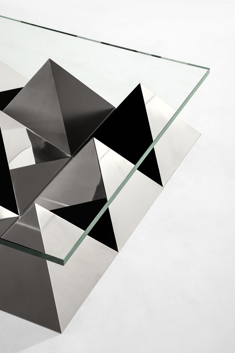 Low table with top in float glass. Base composed of a pyramid in black Marquina marble surrounded by steel pyramids with different faces finishing: black matte paint, satin and polished steel.
Progetto Non Finito collection from Dimoremilano,