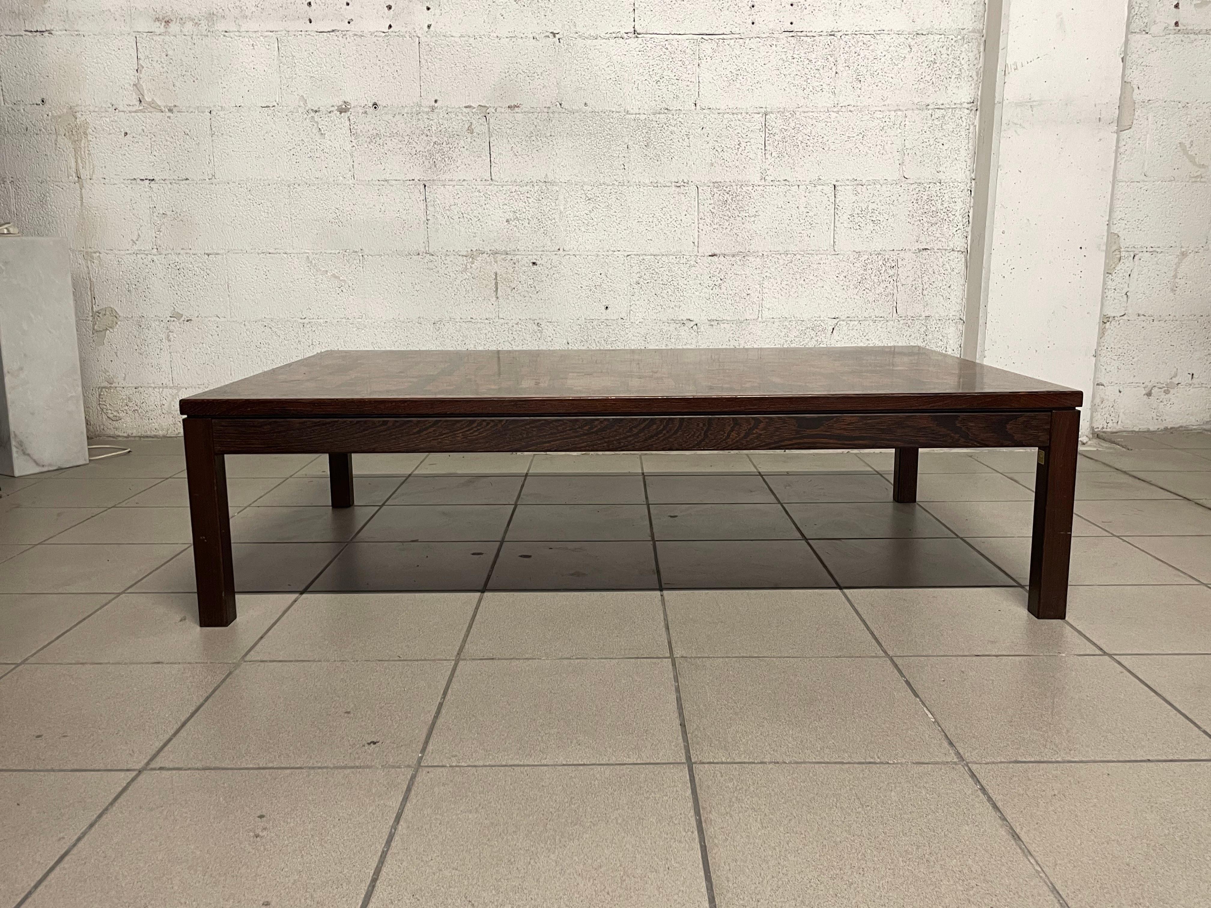 Dänischer Couchtisch, hergestellt in den 1970er Jahren von Tranekaer Furniture nach einem Entwurf von Rolf Middelboe & Gorm Lindum.

Der Couchtisch ist aus Teakholz mit einer Mosaikplatte aus verschiedenen Hölzern.

In diesem Couchtisch findet man