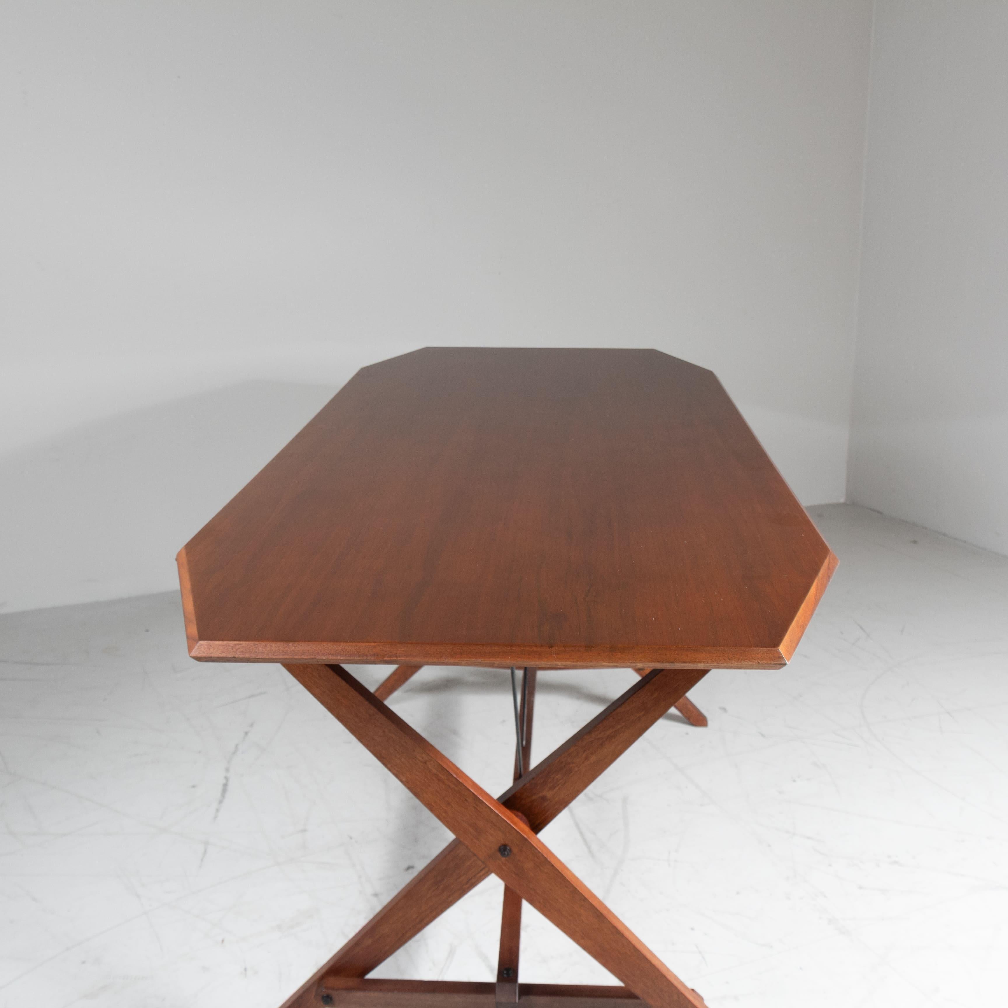 Mesa modelo TL2, conocida como 'Cavalletto', diseñada por Franco Albini en 1950 para Poggi. Armazón de madera con tapa rectangular que descansa sobre dos bases de caballete unidas por una barra de refuerzo. El proyecto representa un equilibrio