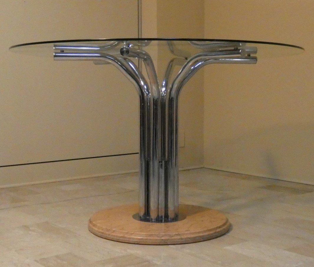 Mesa de comedor redonda con capacidad para cuatro personas.
Base de mármol color salmón pastel y soportes de acero cromado.
Encimera de cristal templado transparente.
Atribuida a Giotto Stoppino, se ofrecía en la época con sus clásicas sillas de