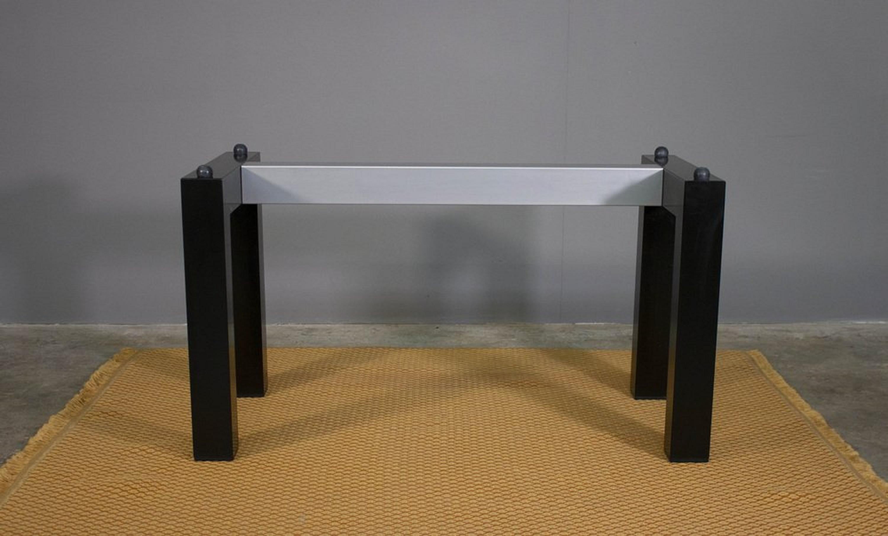 Elegant dining table made in Italy in the 1970s, an authentic example of high-quality vintage design.
The rectangular clear tempered glass top lends brightness and lightness to the structure, while the black painted iron legs and plastic and silver