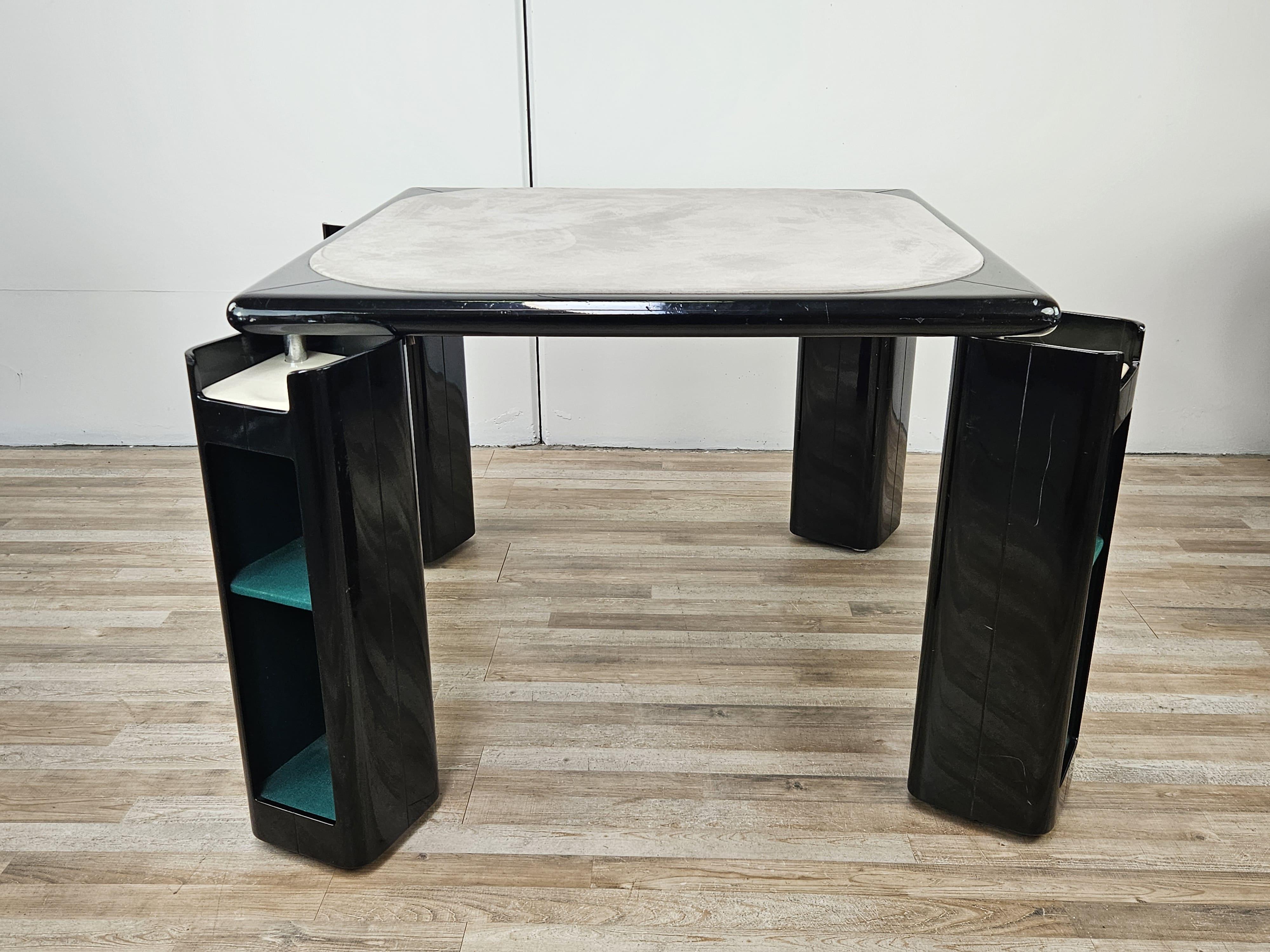 Game table designed in the 1970s by Pierluigi Molinari for Pozzi Milano.

Black lacquered wooden frame with square top and gray fabric center, four rotatable legs with green felt inner compartments.

Refined design furniture element and match it