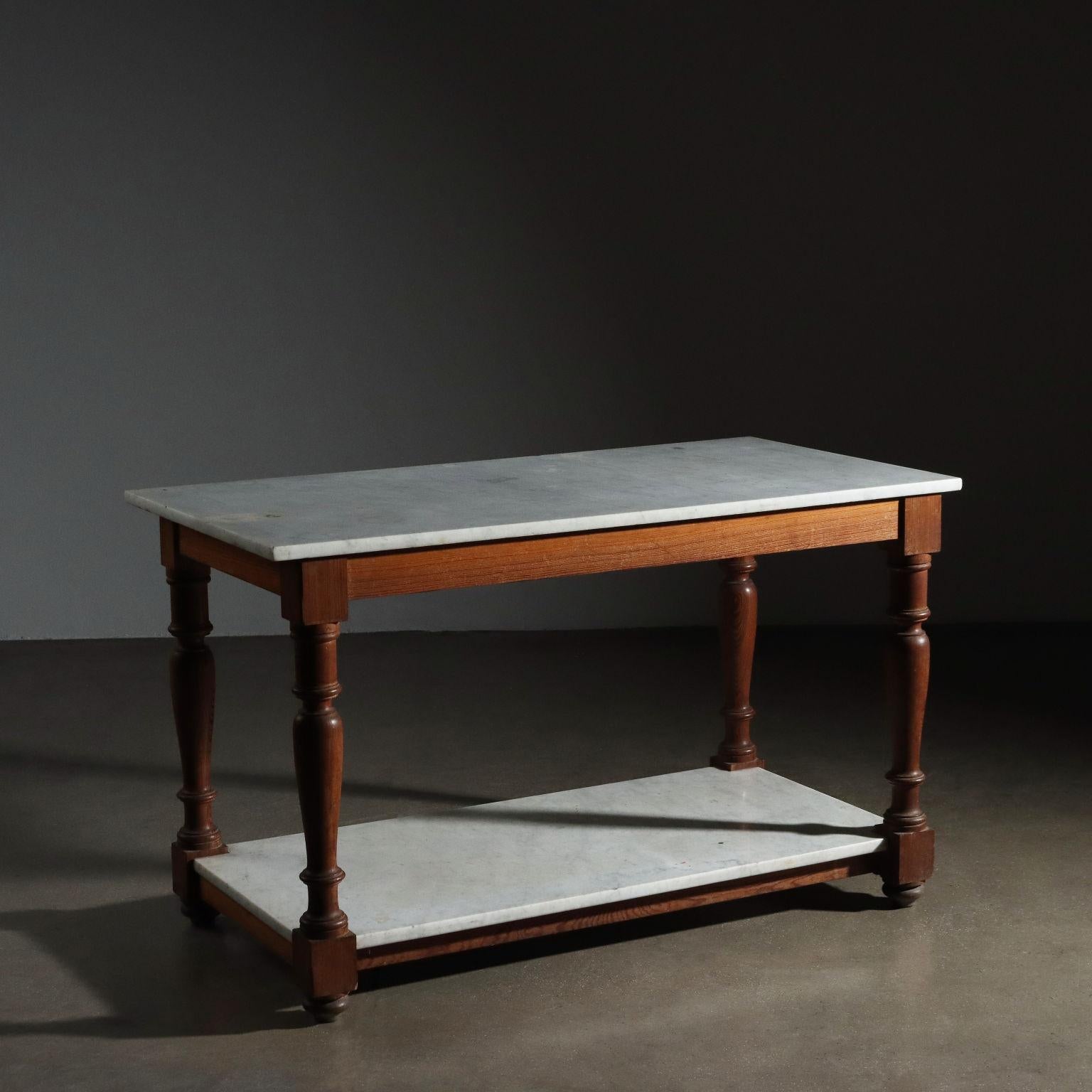 Table de travail en mélèze à quatre pieds tournés reliés par une bande sous le plateau et en bas juste au-dessus du pied tourné. Sur ces bandes reposent deux plateaux de marbre blanc, révisés seulement au nettoyage par nos ateliers, il est prêt à