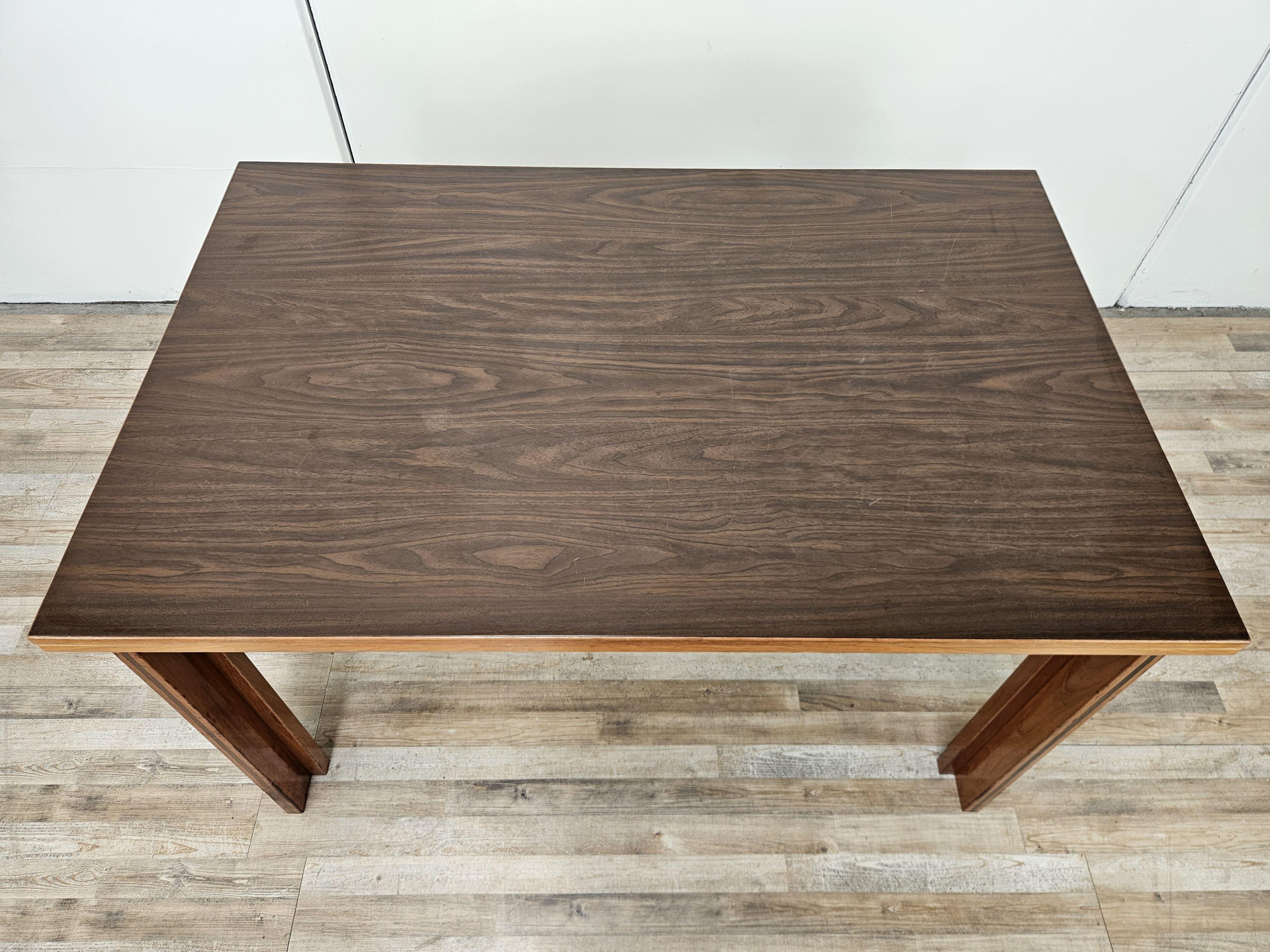 Elegante tavolo da pranzo o da studio in noce e laminato con struttura allungabile e design a libro.

Il tavolo è una manifattura italiana di alta qualità costruttiva e dal design moderno con richiami agli anni '70. 

Misure contenute, perfetto per