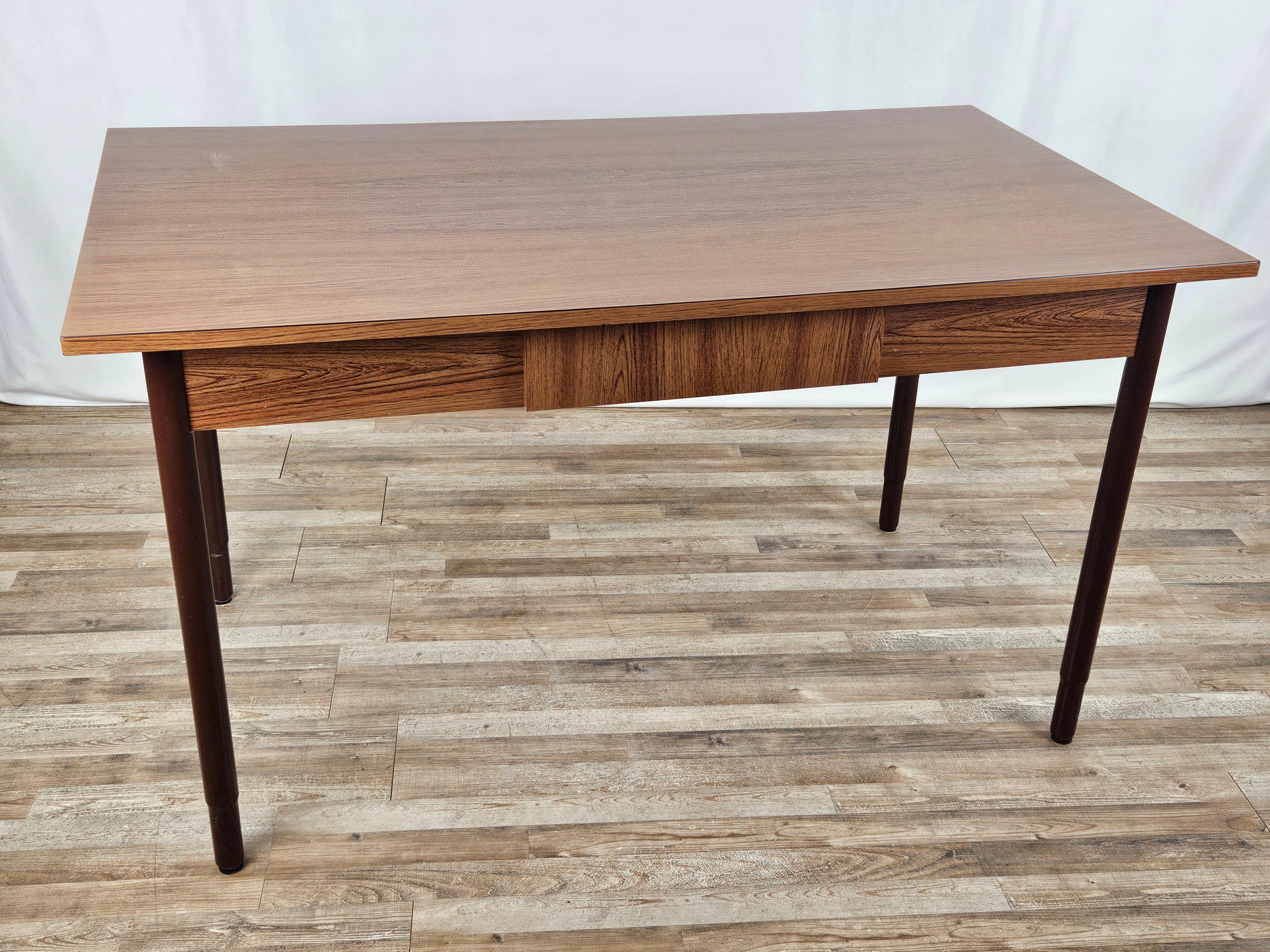 1970s brown formica dining table with metal legs and central drawer.