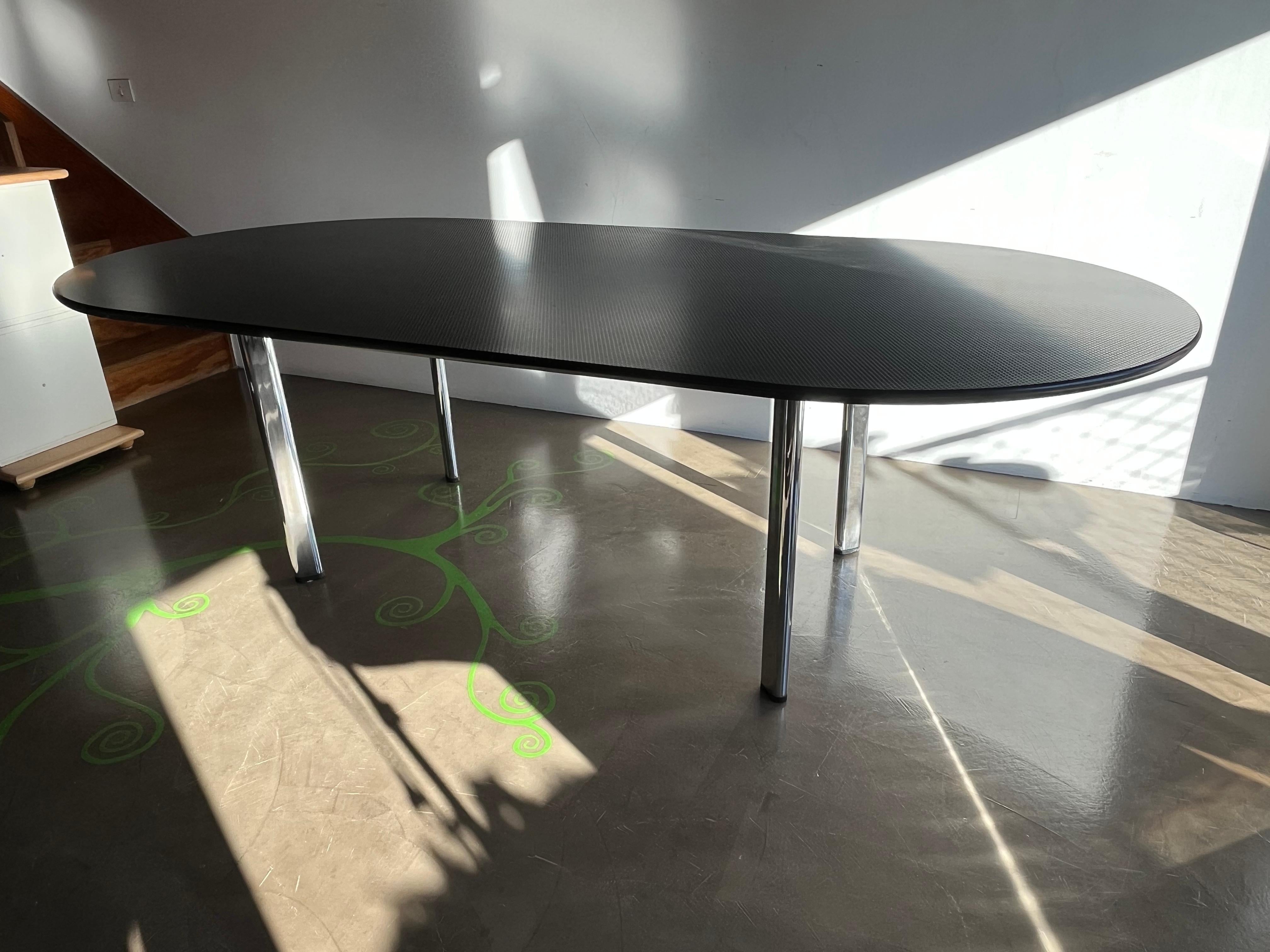Interesting and impressive oval table ideal as a dining table or meeting room table. 
The table has a rectangular steel frame, wooden top covered with rubber material with stamp pattern. It recalls the same material used in the 1960s for the Milan