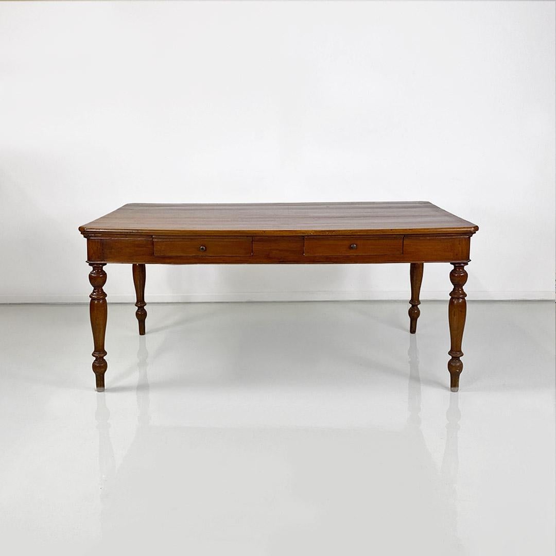 Dining table, also usable as a large desk, with double drawers made entirely of solid walnut wood, with brass knobs, rectangular top with beveled corners and turned legs.
Dating from around the early 1900s.
Good condition, some signs of wear on the