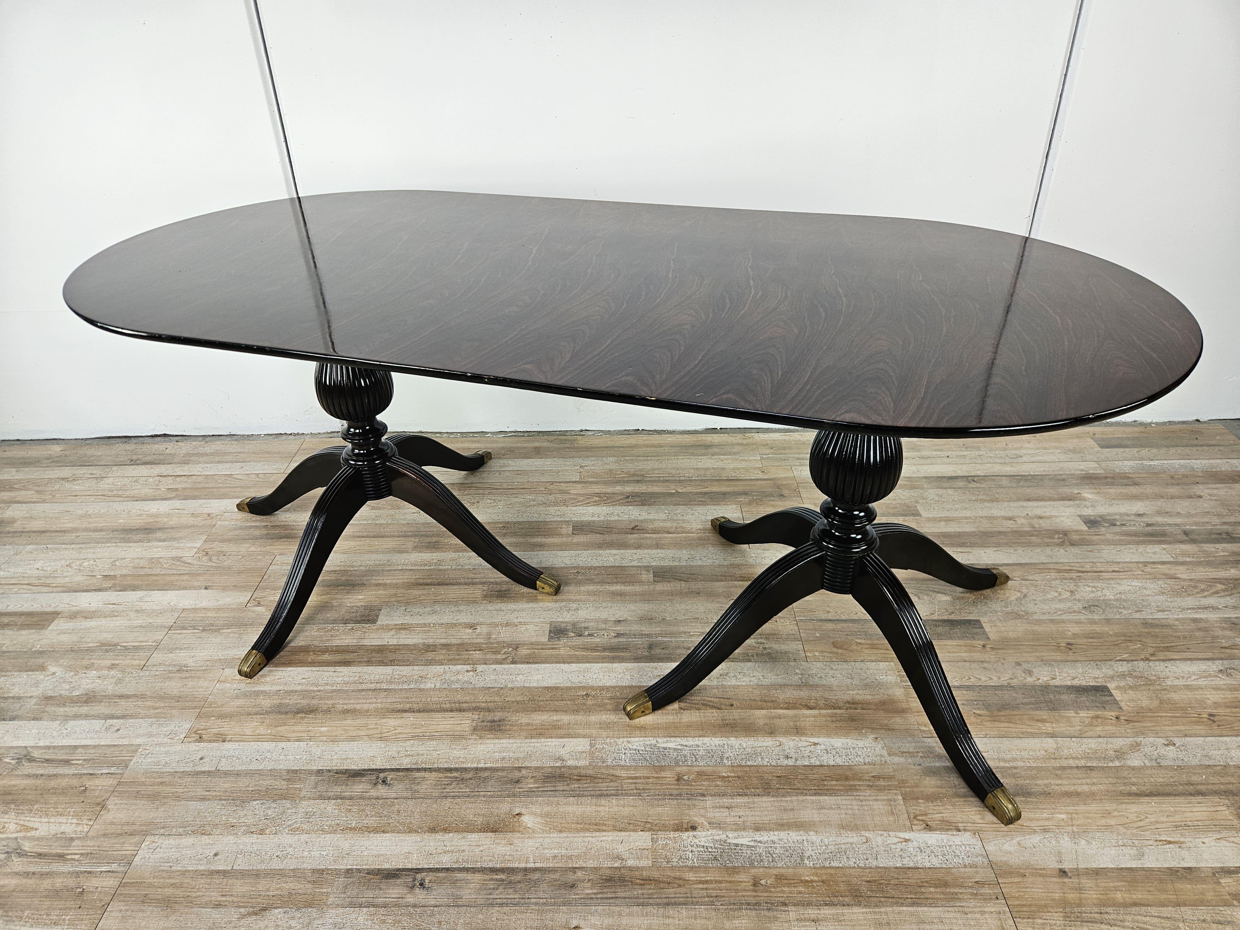 Mesa de comedor ovalada de los años 60 con tablero recubierto de palisandro y base doble tallada.

Muy elegante y refinado, ideal para habitaciones de estilo vintage, victoriano antiguo o moderno. 

Observe las punteras de latón, que también están