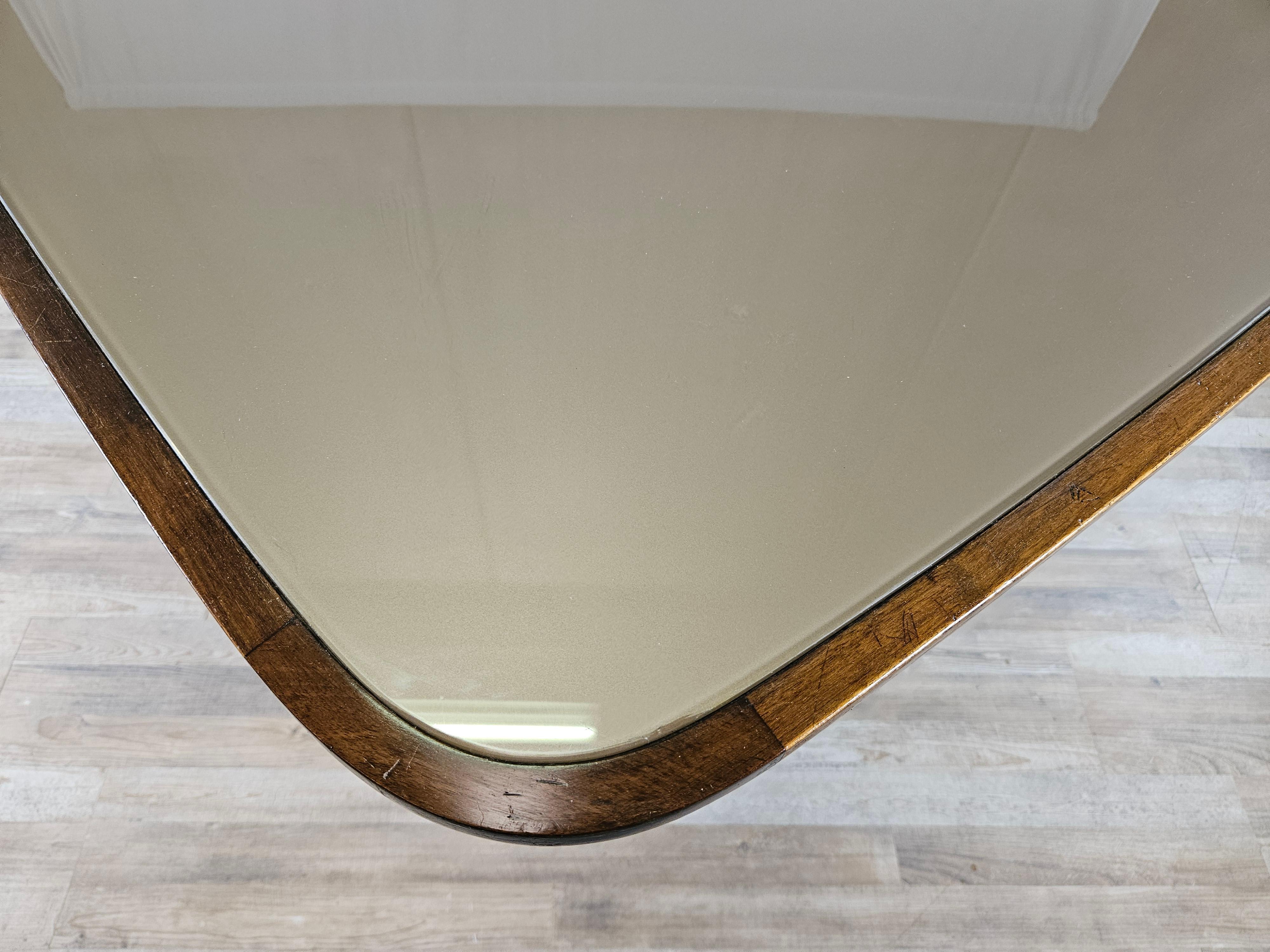 Elegant and refined Italian dining table produced at the turn of the 1940s and 1950s, with a design that moves slowly from Deco to Italian modernism with linear forms and well-defined designs.

The brown glass top is original to the period, has