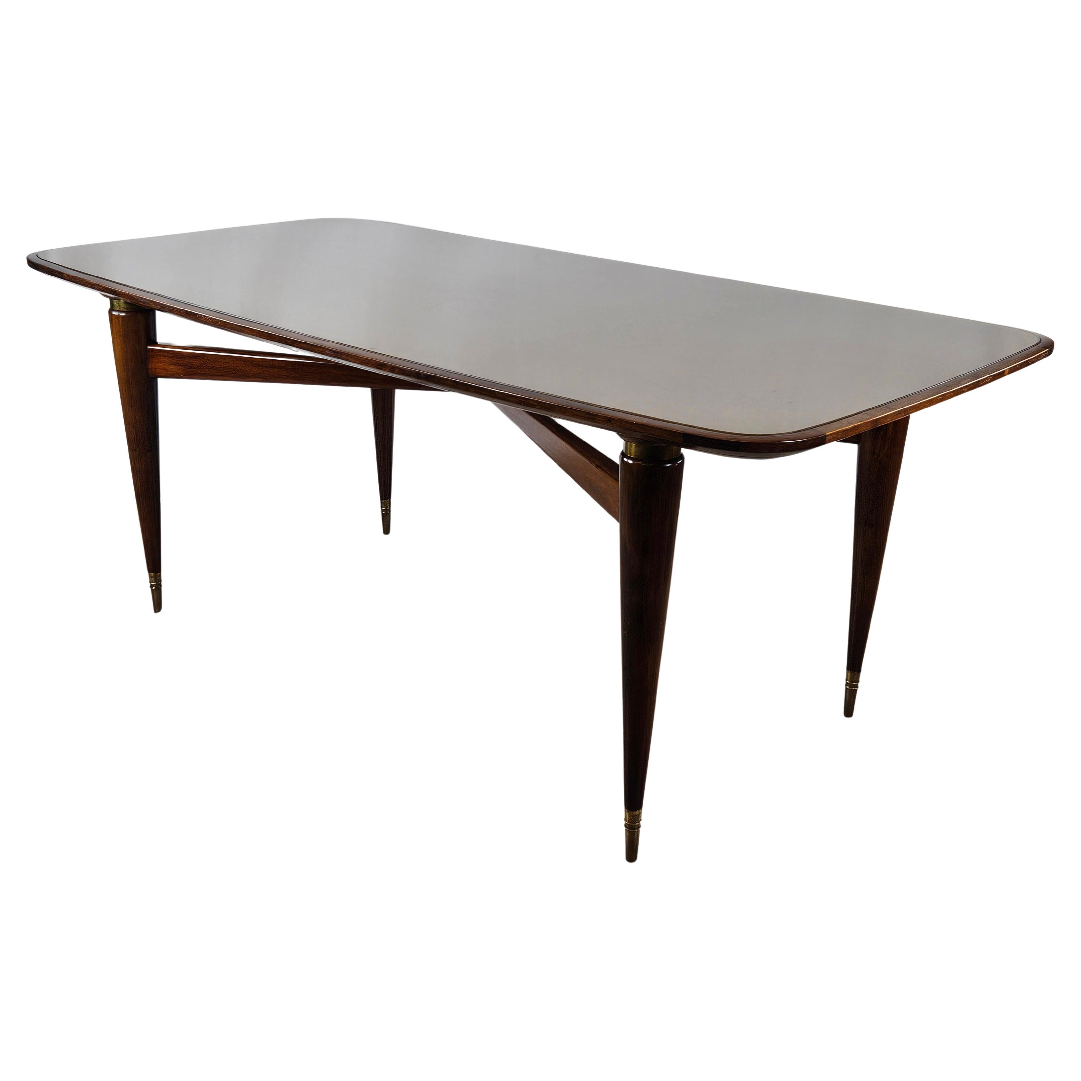 Rectangular walnut dining table with glass top and brass decorations For Sale