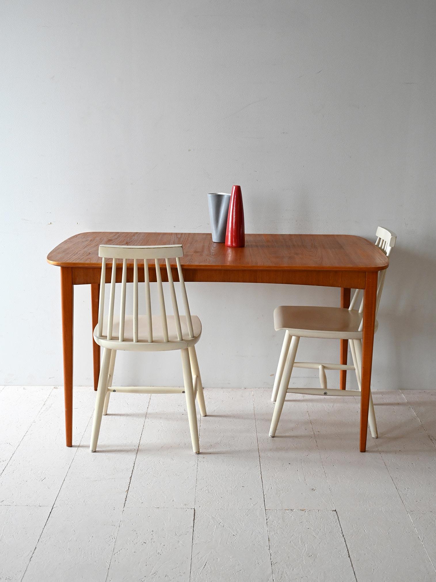 Teak dining table with a 50 cm central extension leaf. Soft lines and balanced proportions.

Scandinavian teak dining table, dating from the 1950s/60s, characterized by rounded shapes and light frame. The rectangular top has a central 50-cm