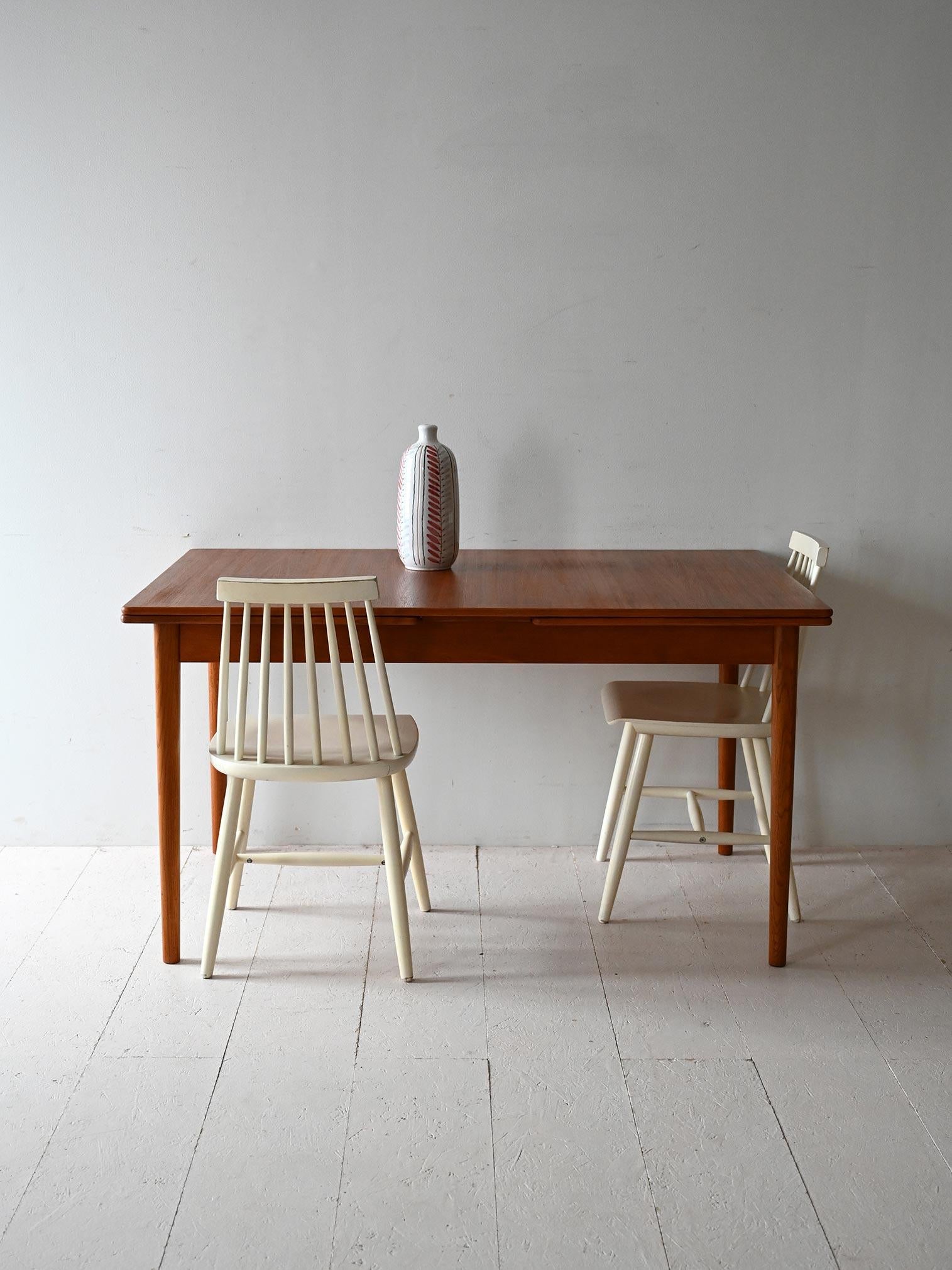 1950s/60s table by Nils Jonsson for Troeds, with two side extensions and original stamp.

Signed by Nils Jonsson for Swedish manufacturer Troeds, this teak dining table dates from the 1950s/60s. The frame features a rectangular top with two