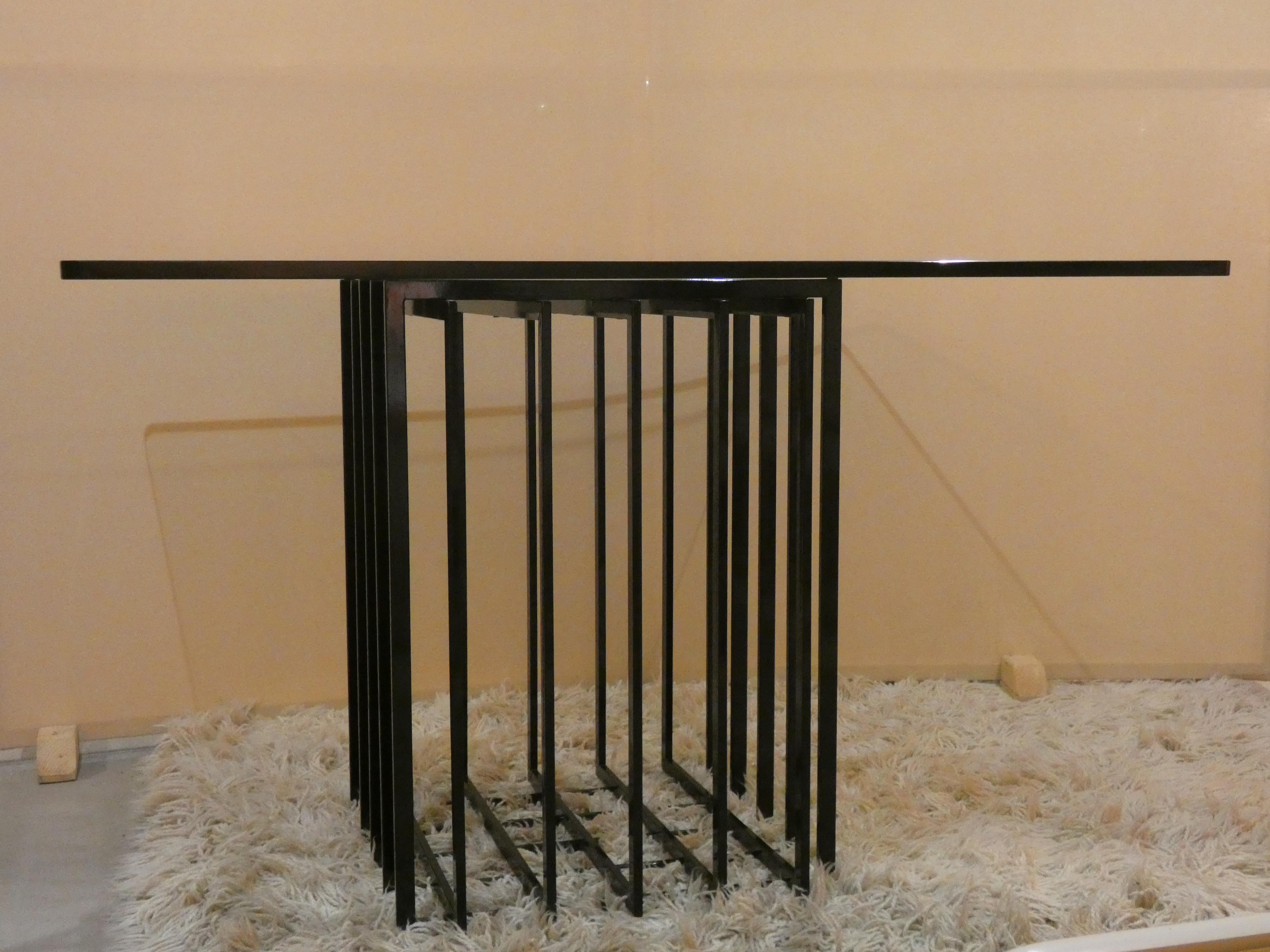Importante table de salle à manger/studio produite dans les années 1970 en France, conçue par Pierre Cardin. Grâce à l'utilisation d'une grille de section rectangulaire en acier peint en noir, il présente une élégante expression ouverte. Le plateau