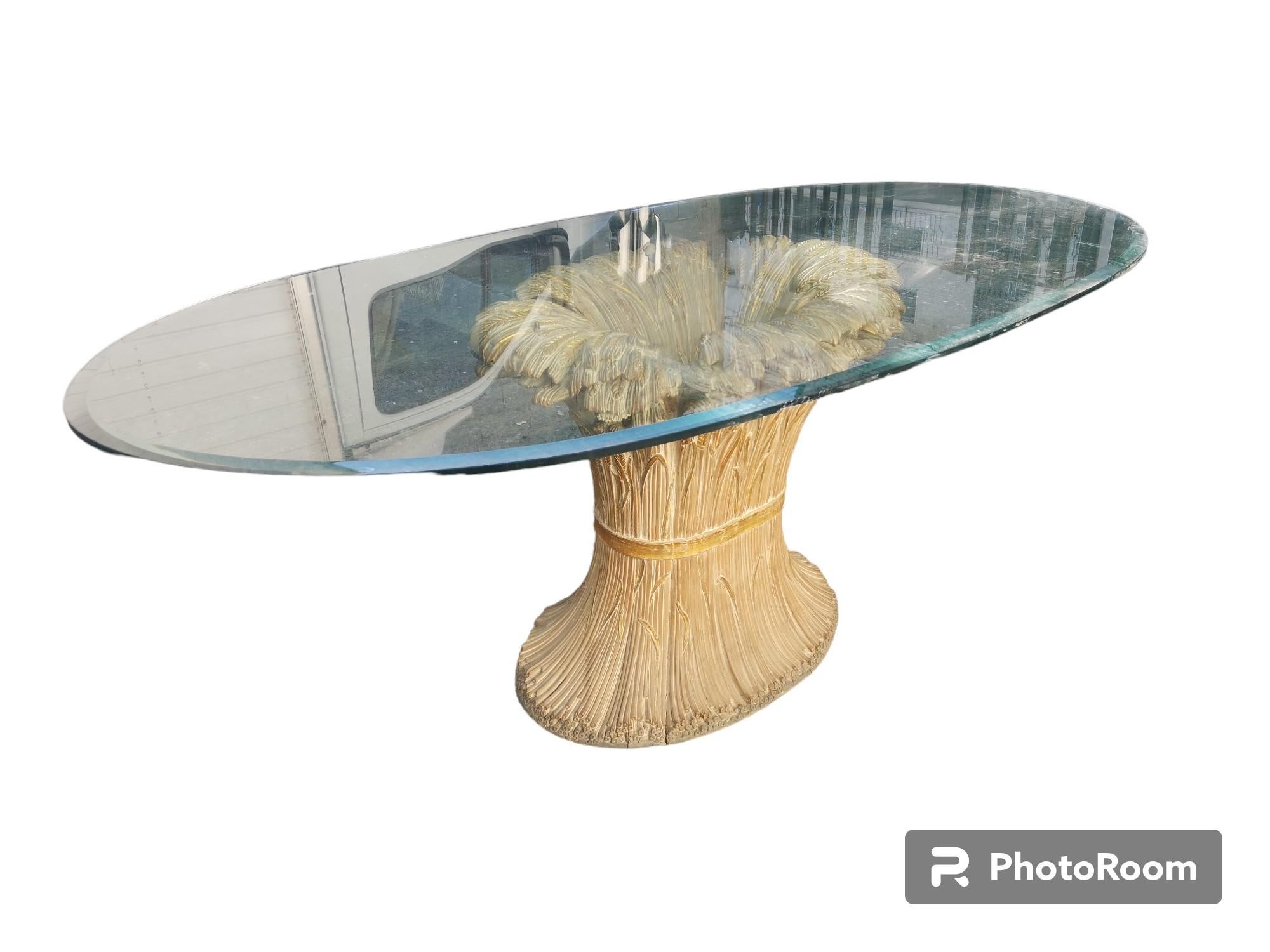 Dining table 176 by Chelini Florence 1970s, at base a sheaf of wheat tied by gilt ribbon in carved wood and thick glass top.


