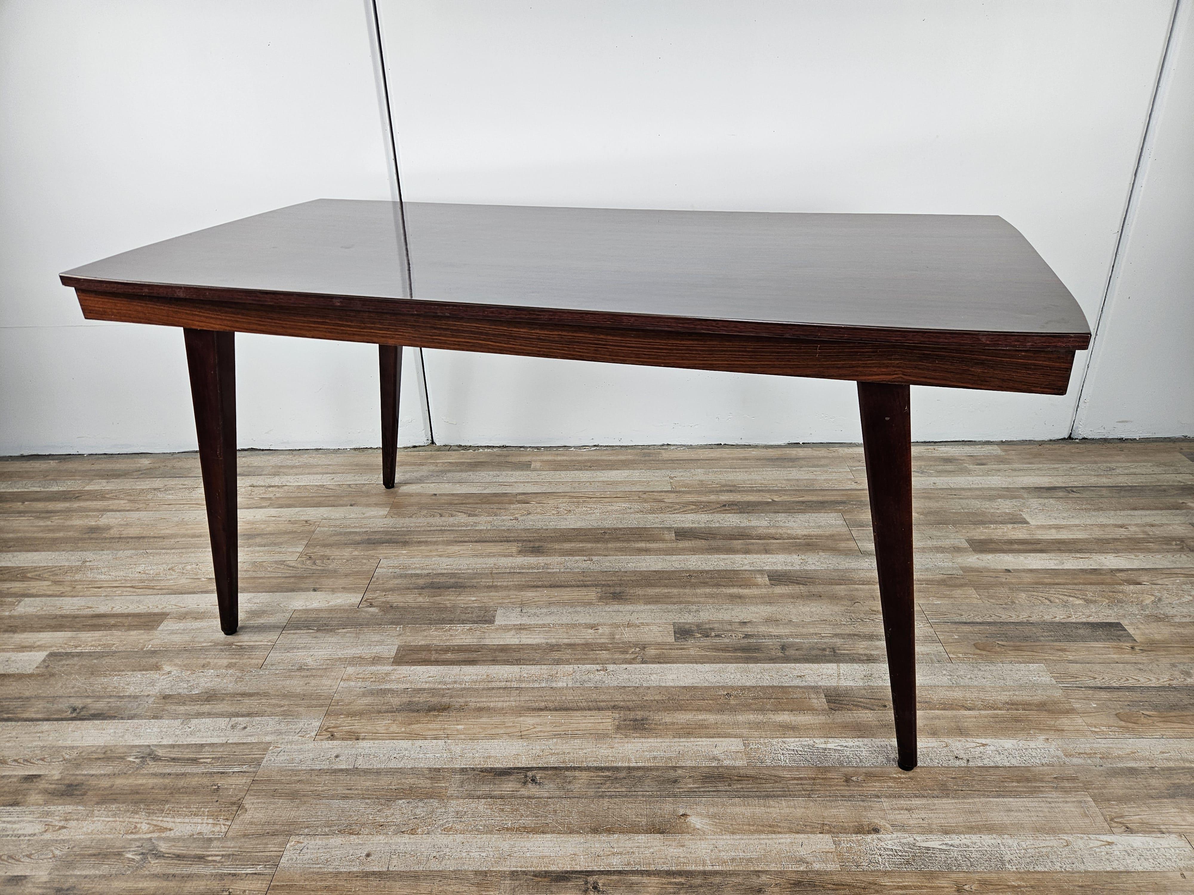 Elégante table de salle à manger vintage en bois de rose stratifié, fabriquée au début des années 1960 environ.

Ses dimensions particulières le rendent idéal et adaptable à tout type de mobilier, même dans les pièces étroites.

La table présente