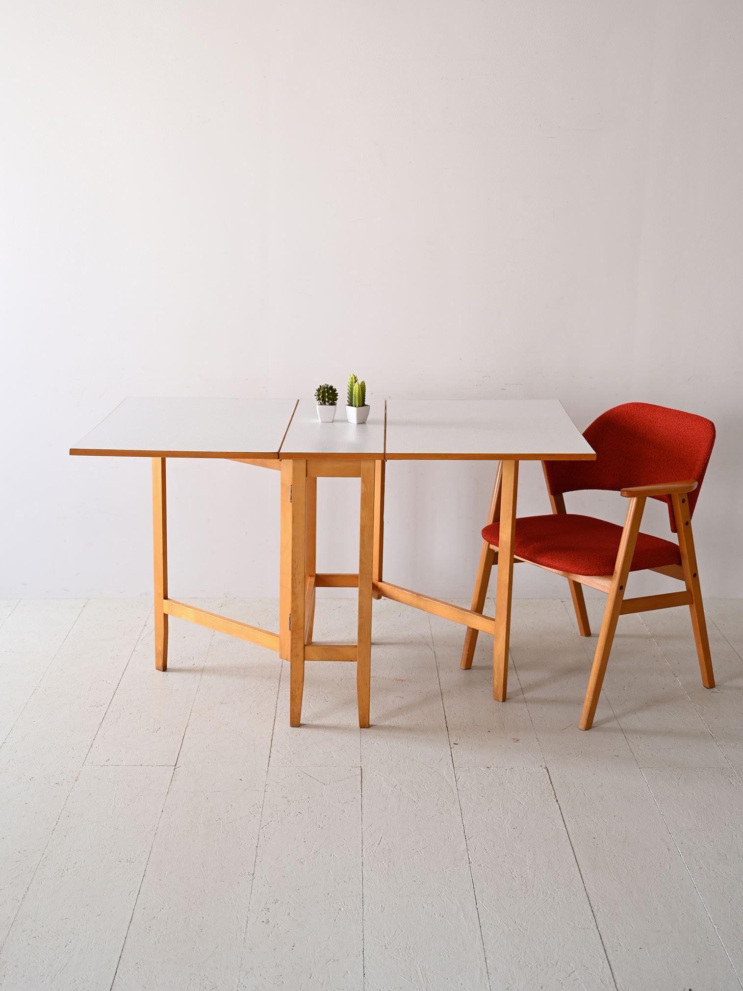 This Scandinavian extending table, with its durable formica top and teak wood edges, is a perfect example of functional design. Designed to fit flexible spaces, the table can be extended to accommodate additional guests, making it ideal for