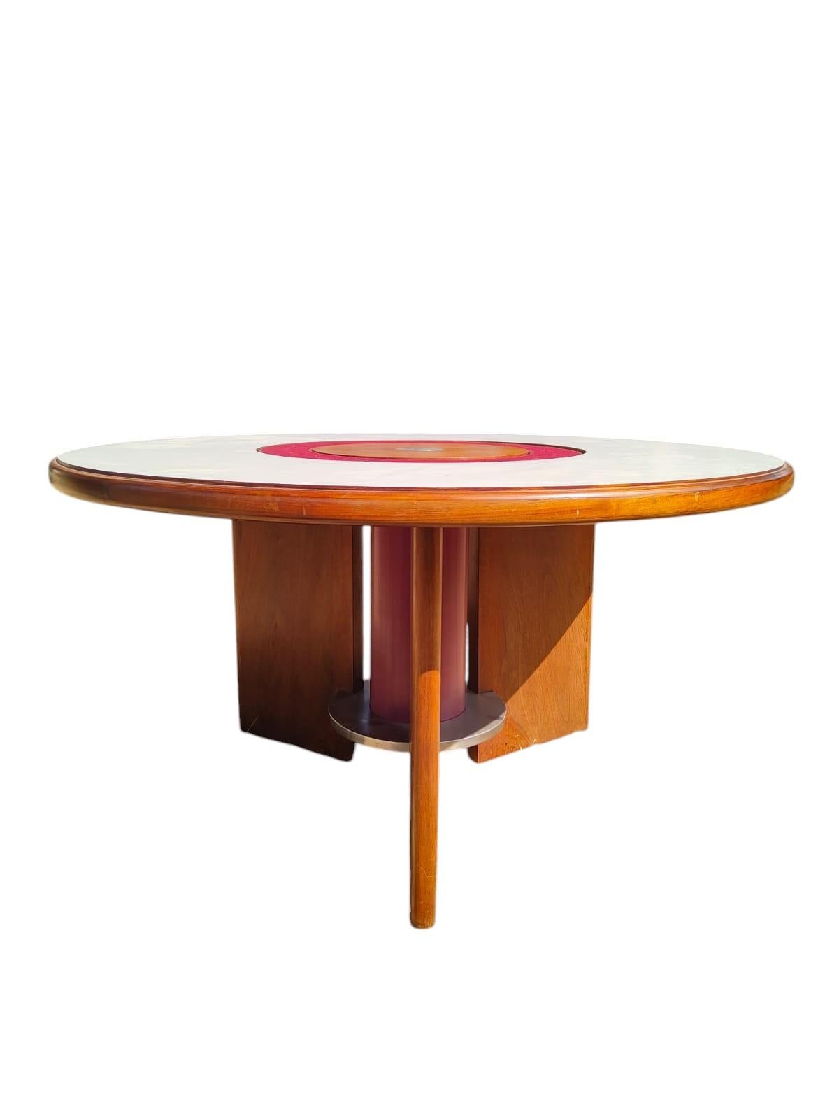 Bellissimo tavolo circolare in legno di noce, con piano il laminato ed acciaio, progettato da Silvio Coppola per Bernini, marchio storico del design italiano, negli anni '70.

Il tavolo ha un ingegnoso meccanismo nella parte centrale che permette di