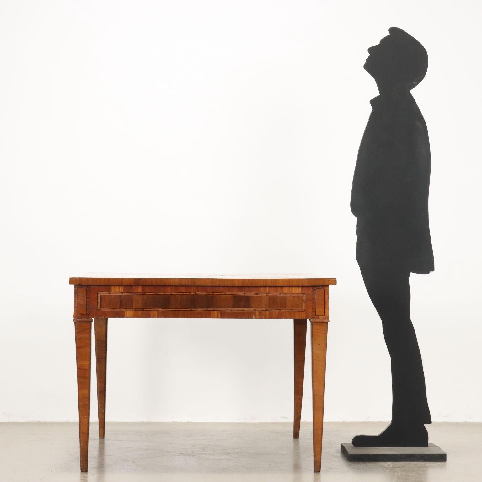 Neoclassical table made of square-section poplar, fully planed. Inlaid top with geometric score made from olive and carob borders, crossed to form four small inlaid rosettes; the reserves are veneered in quadripartite walnut; the fillets outlining