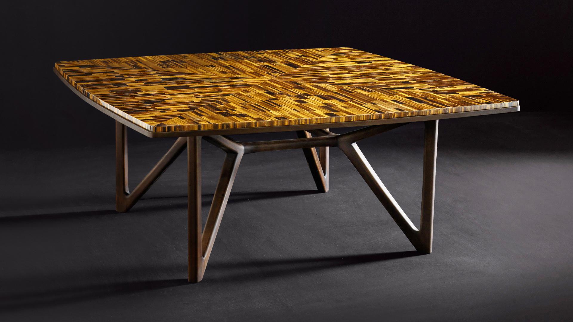 Dining table in Tiger’s Eye stone with wood basement.
Table with a dark wood structure and a mosaic made with Tiger’s Eye stone. The tiles create an iridescent effect, a very suggestive mix of light/dark shades. 
Table dimensions are: 180x180 cm and