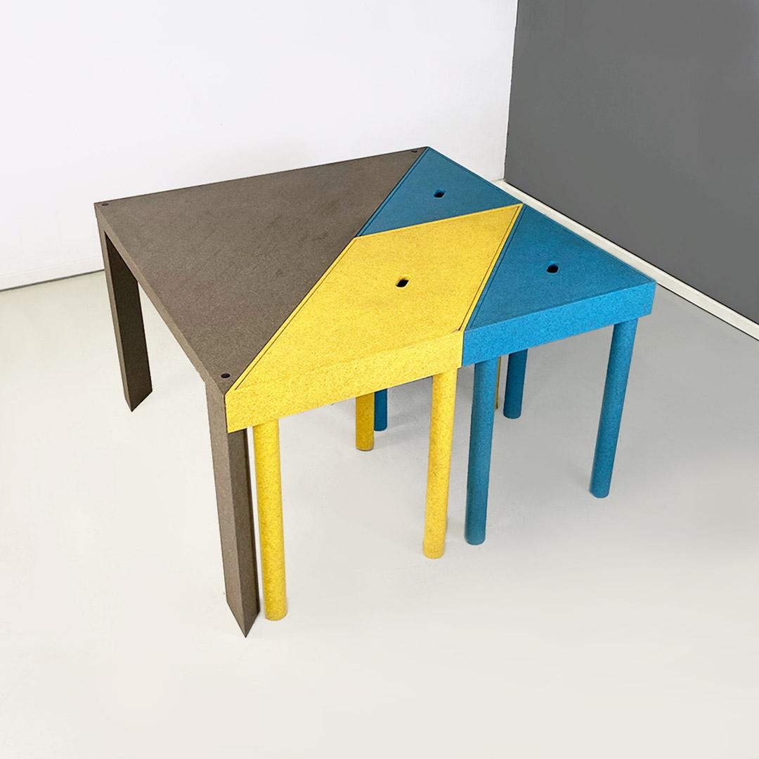 Tangram model modular table that can be used in various configurations as a dining table, console table or desk. Composed of four pieces, two of which are triangle-shaped twins, blue in color, one yellow with a trapezoid shape, with a removable lid