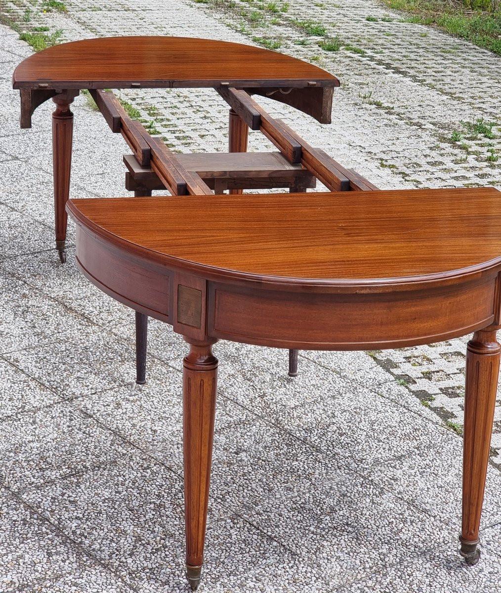 Elegante tavolo ovale allungabile in legno di mogano, databile ai primi del Novecento. Il piano, pellicciato in mogano, misura 110 x 139 cm da chiuso e può raggiungere una lunghezza massima di 270 cm in posizione estesa. Le prolunghe originali non