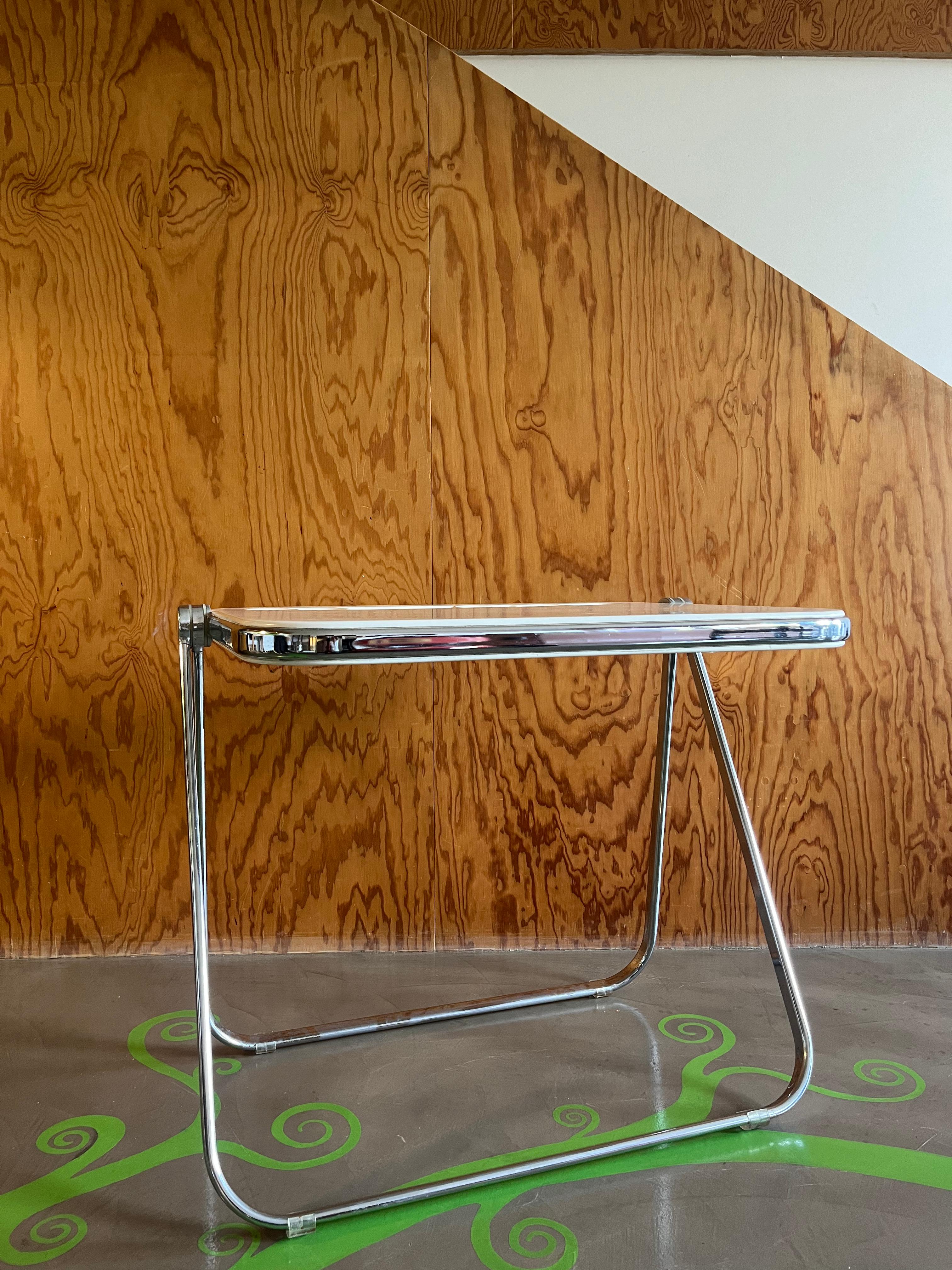 Iconic folding table with white polycarbonate top with storage compartments and silver chromed metal legs. The table is named Plato, was designed by Giancarlo Piretti (Bologna - 1940), a great Italian designer, in 1970 and produced by the Italian
