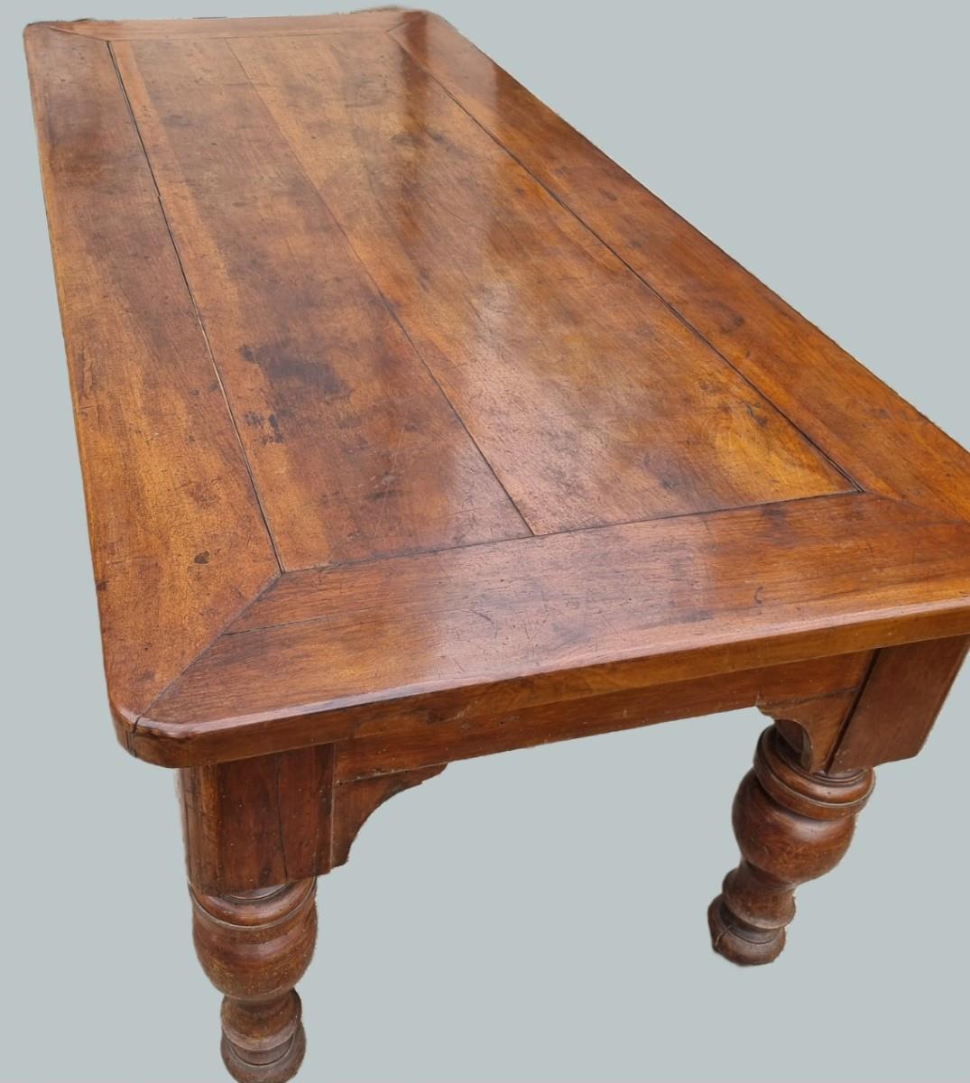 Tavolo rettangolare di manifattura piemontese, realizzato in noce massiccio e databile alla prima metà del XIX secolo. Il piano presenta un’elegante cornice a filo inclinato con fasce laterali ben raccordate, che incorniciano le assi centrali dal