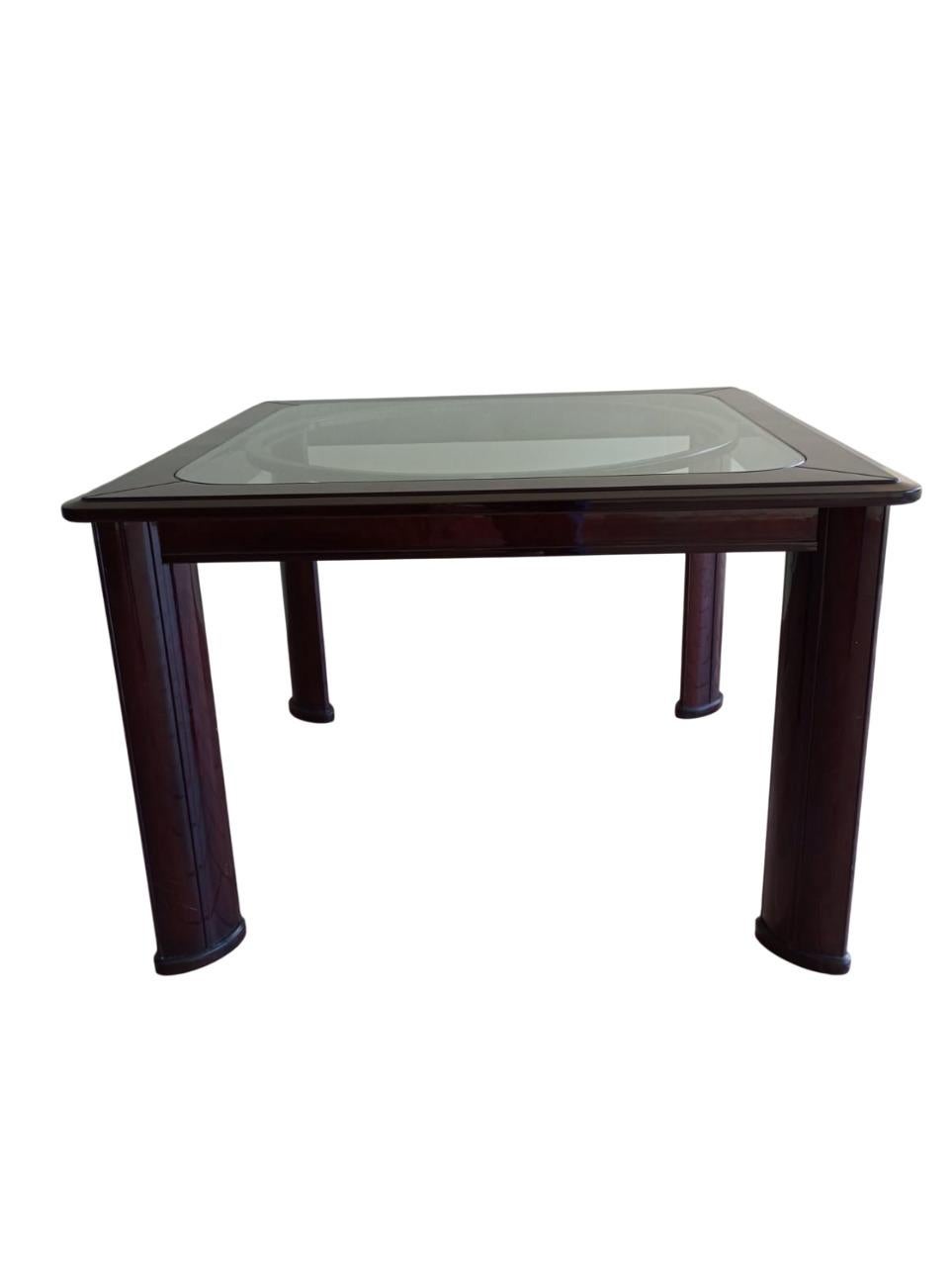 Tavolo quadrato elegante esempio di Art Déco francese degli anni '60 in legno
lucido utilizzato sia per la struttura, che per le gambe. La superfice del piano è in vetro incassata in una cornice di legno. Le gambe sono con forma ad ellisse . La