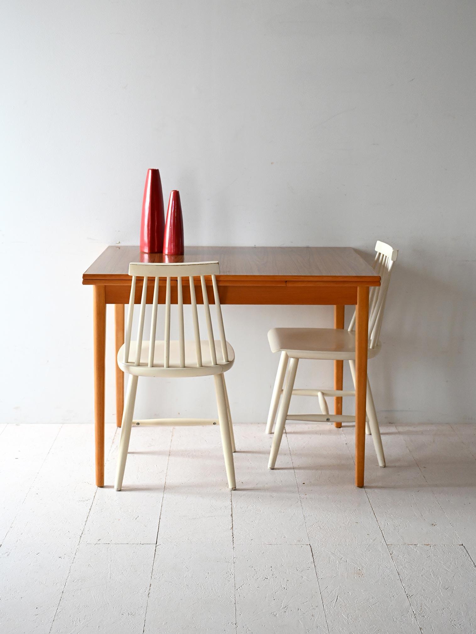 Table from the 1950s/60s with teak frame, formica top, and two retractable side extensions.

Understated and functional design for this Scandinavian rectangular table dating from the 1950s/60s. The frame is teak, with a clear formica top with