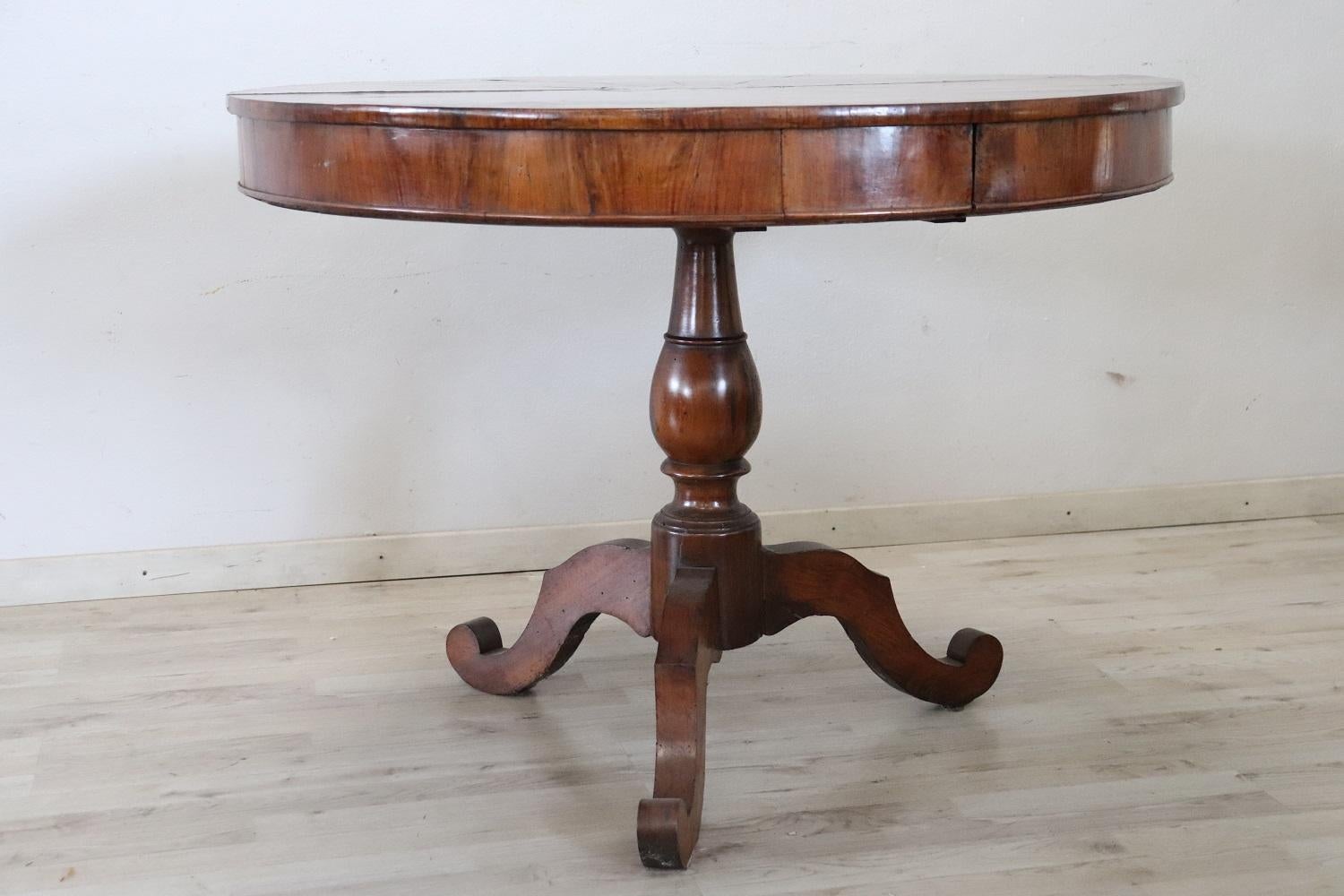Table centrale ronde italienne raffinée en bois de noyer. Table d'époque Louis Philippe du 19ème siècle. Il est doté d'un élégant pied central tourné. La partie supérieure est ornée d'un décor incrusté raffiné avec une étoile centrale. Équipé d'un