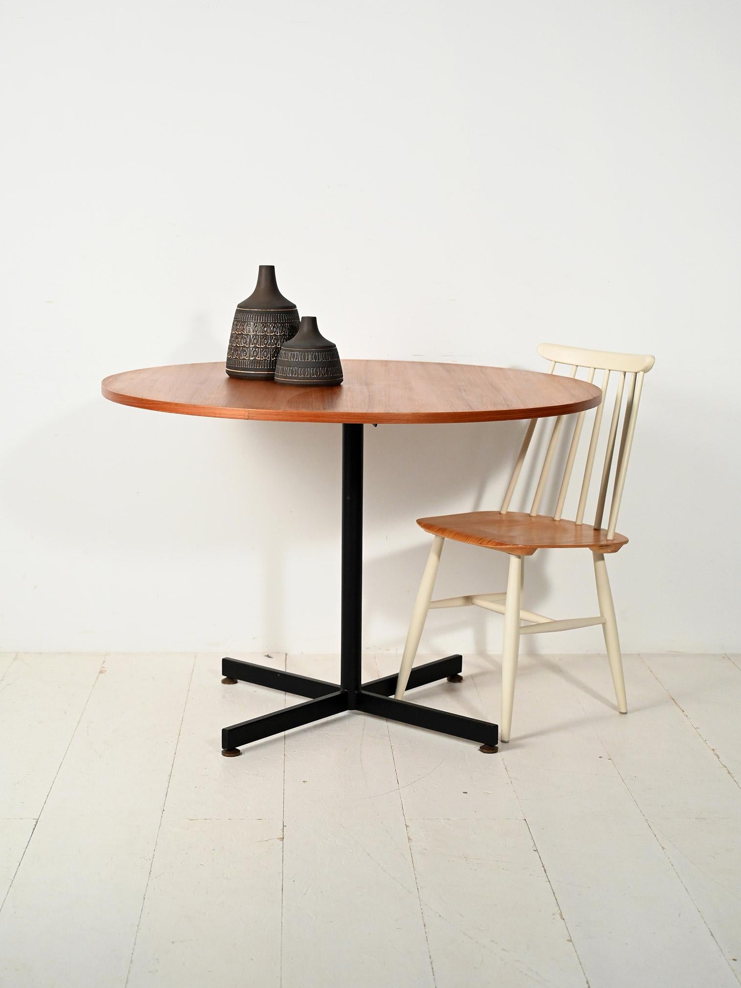 Tavolo scandinavo vintage con piano rotondo in teak e struttura in metallo verniciato nero, design essenziale anni '60.

Tavolo scandinavo vintage con piano rotondo impiallacciato in teak e base in metallo verniciato nero. Il disegno sobrio,