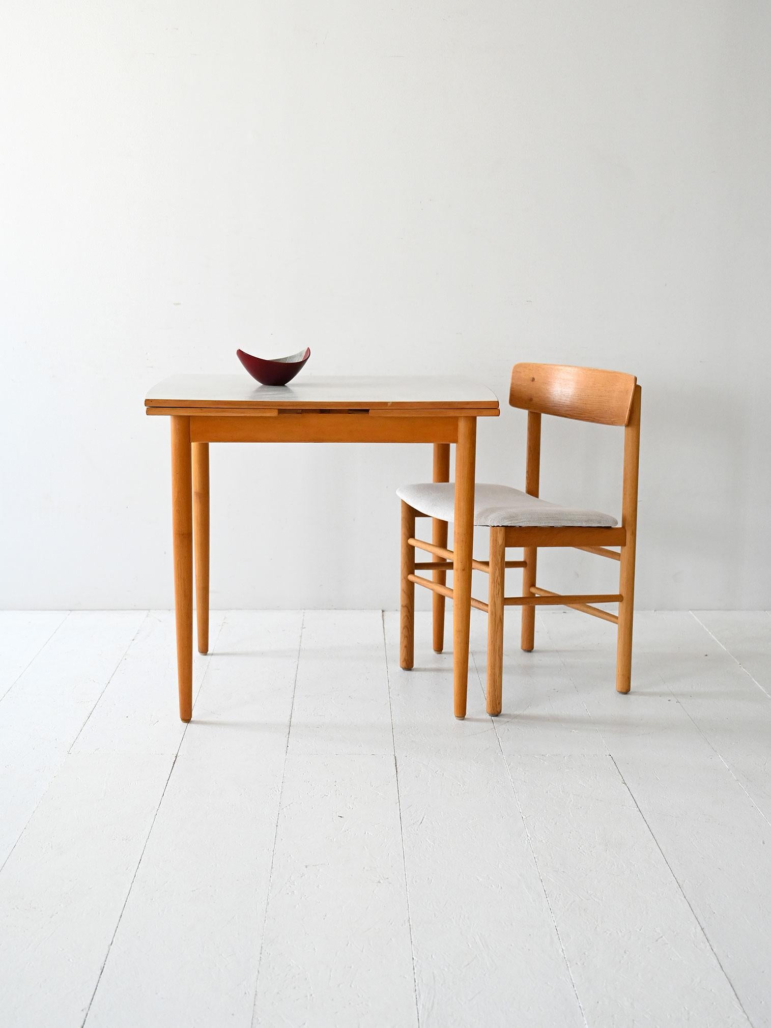 Table scandinave des années 1960 fabriquée par Edsbyverken, structure en hêtre, plateau en formica gris clair avec deux rallonges latérales.

Table extensible scandinave vintage, fabriquée par Edsbyverken en Suède dans les années 1960.
Le cadre est