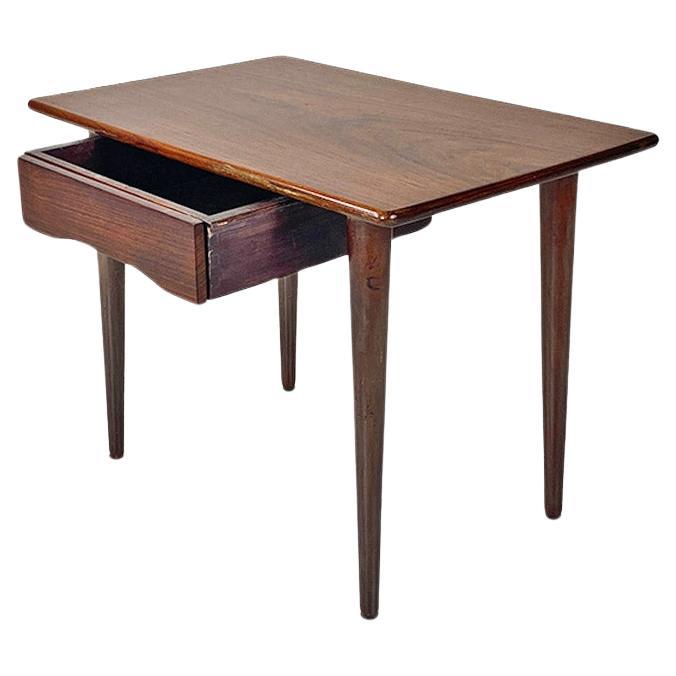 Scandinavian mid-20th-century wooden table with central drawer, ca. 1960.