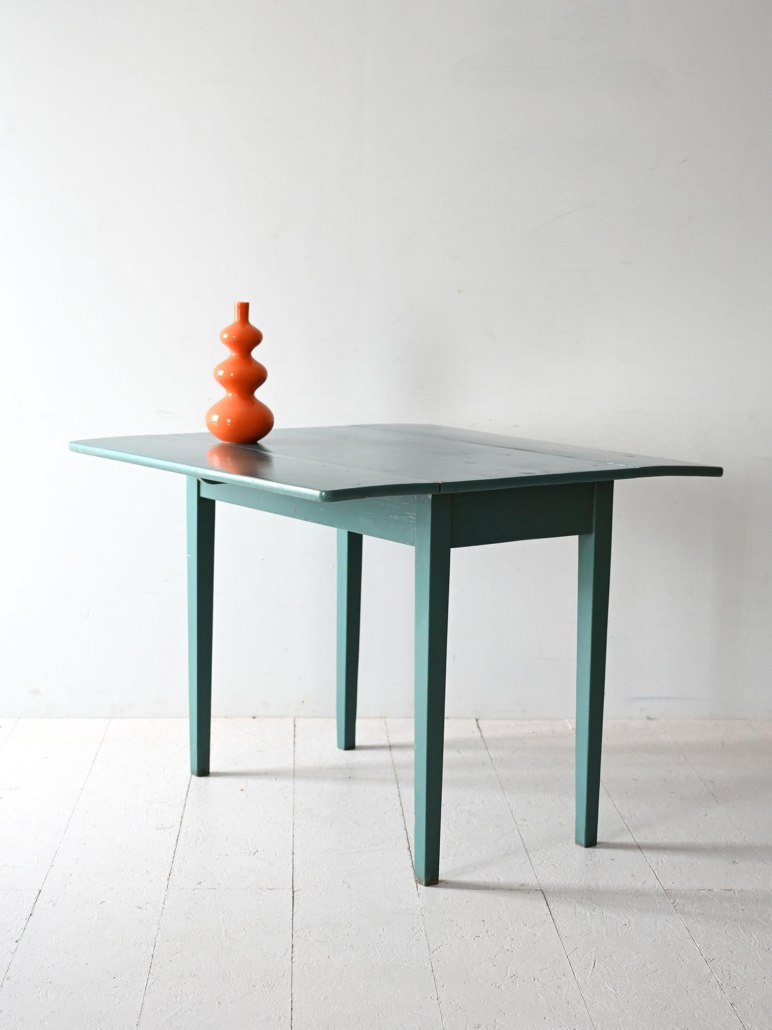 Vintage Scandinavian table from the 1950s with wooden frame and tapered legs. Folding top with two side extensions.

Vintage Scandinavian table from the 1950s, made of wood with a solid frame and tapered legs. The rectangular top is equipped with