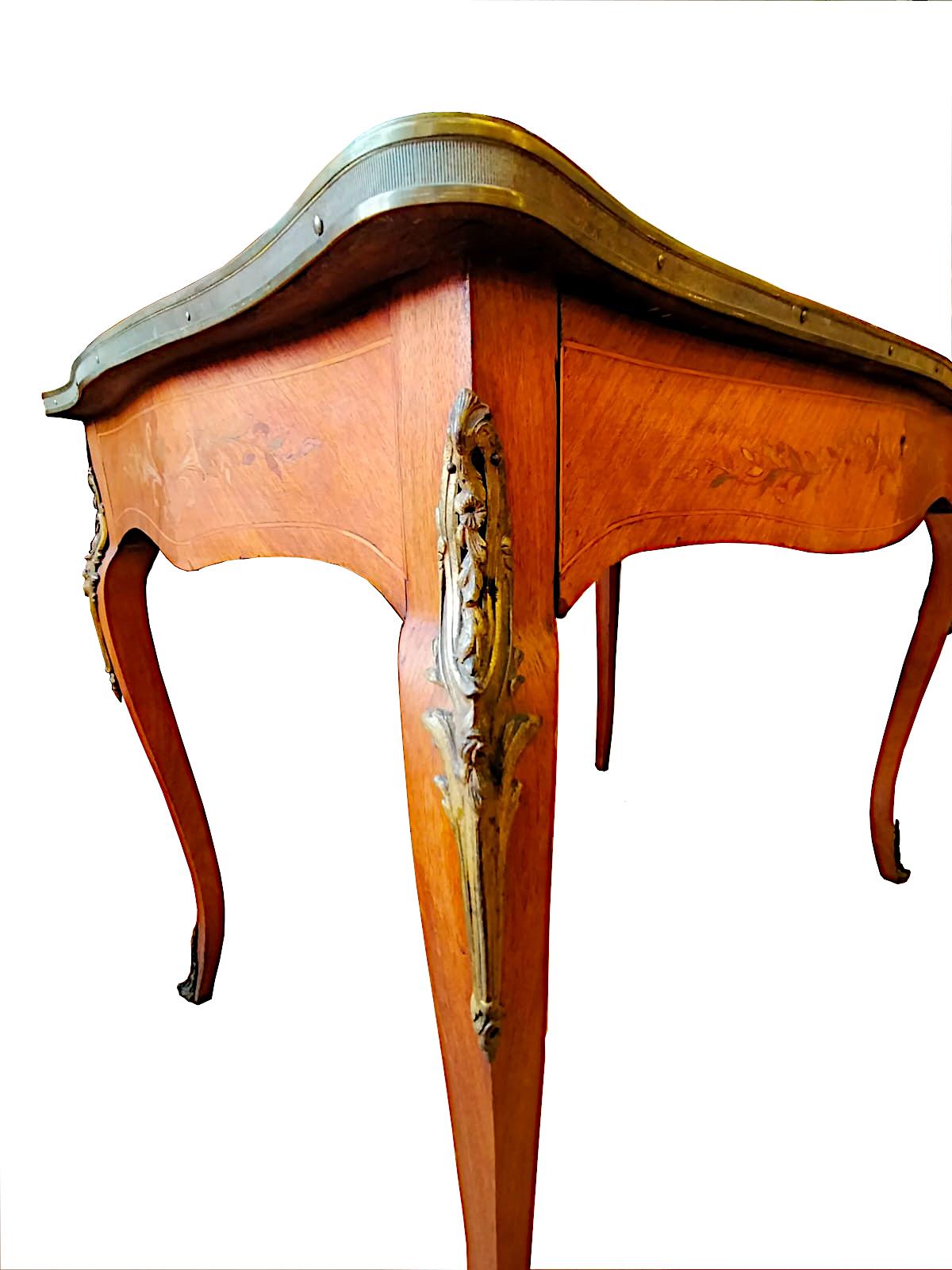 Table à écrire en marqueterie de style Louis XV

Table à écrire française, de forme élégante, de style Louis XV, avec tiroir et bronzes décoratifs dans les pieds et le contour du plateau.
Période : fin du 19e siècle début du 20e siècle.
Entièrement