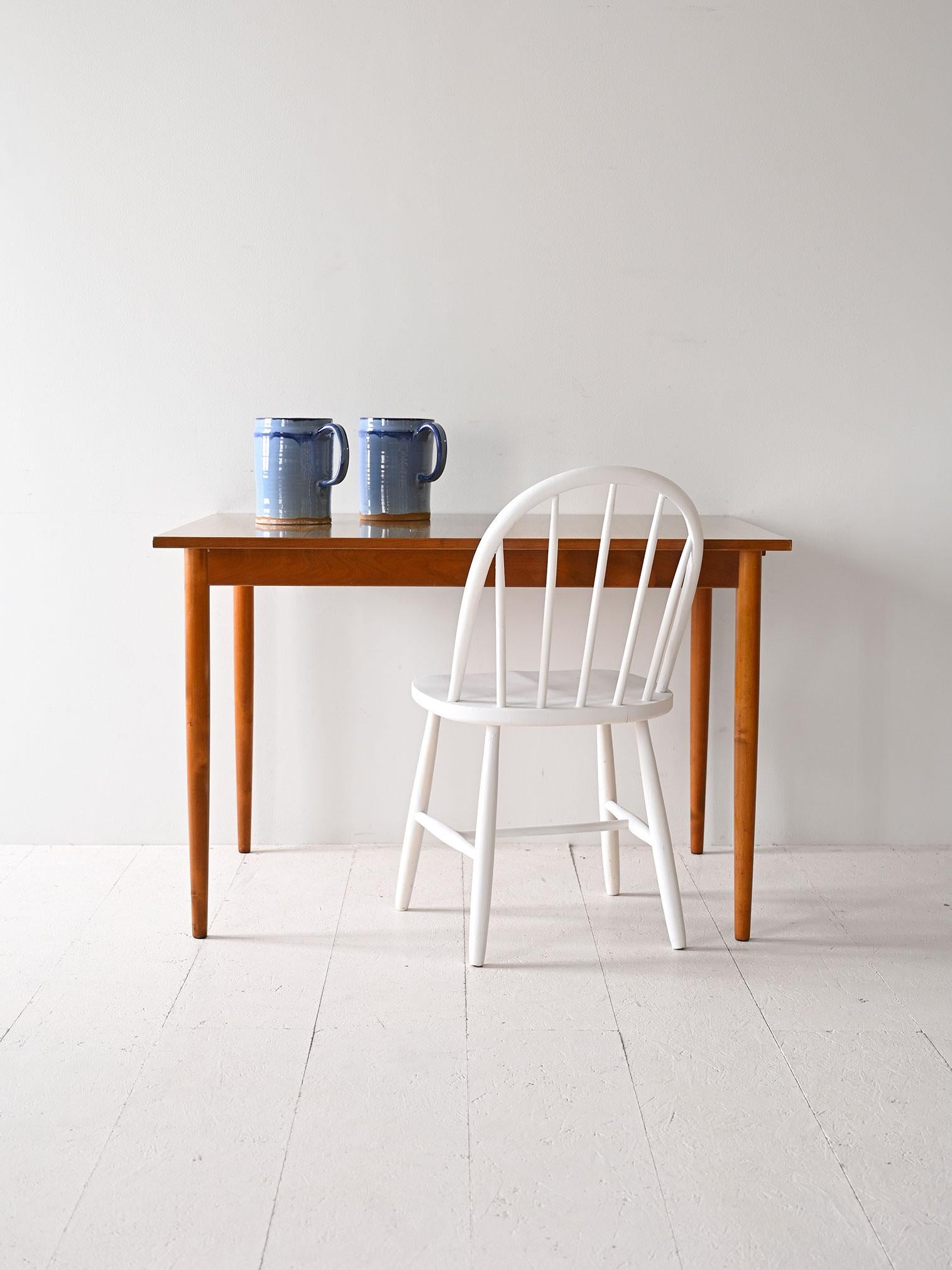 Vintage-Esstisch mit Formica-Platte in Holzoptik. Er hat eine ausziehbare Seite. 

Die Beine aus Birkenholz verleihen einen Hauch von natürlicher Eleganz und sorgen für Stabilität. Der Tisch hat eine ausziehbare Platte, mit der die Länge von 110 cm