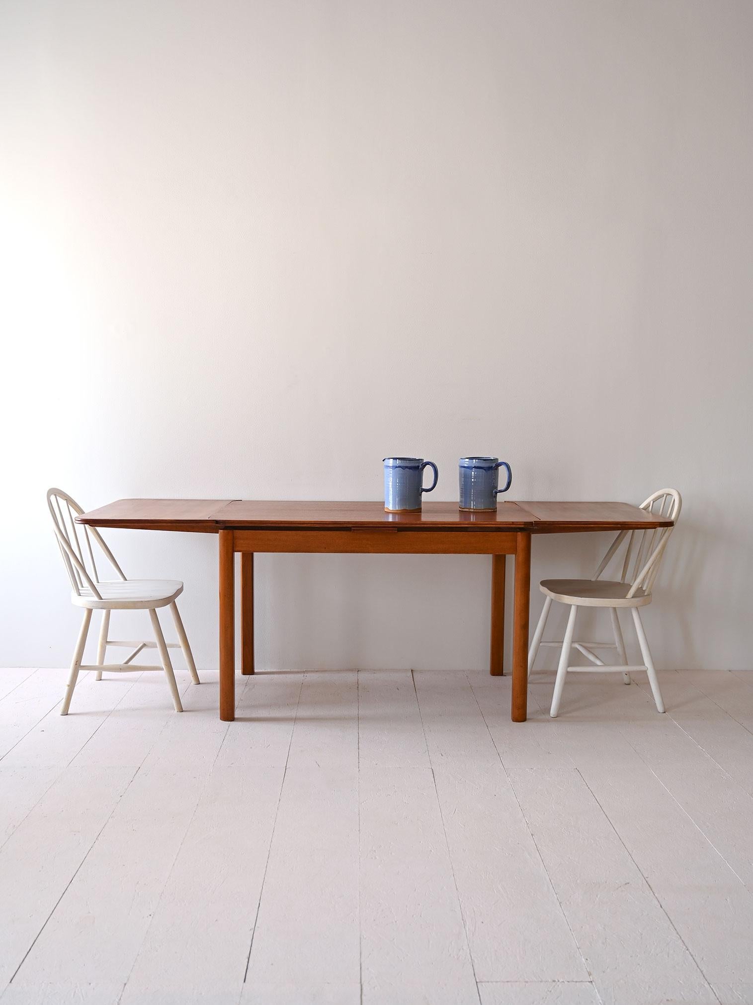 Élégante table du milieu du siècle produite dans les années 1960 au Danemark. 

Table à rallonge robuste avec plateau en acajou. 

Les pieds et les angles arrondis confèrent de la modernité au design minimaliste de ce meuble scandinave