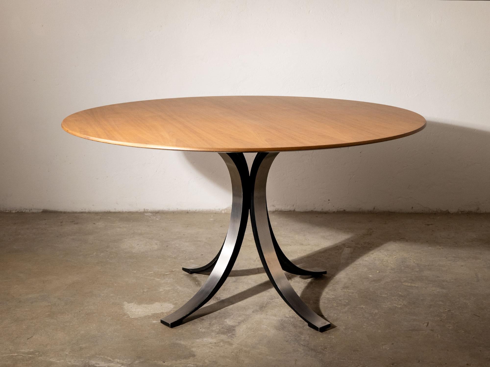 Il tavolo T69 presenta una base ispirata all'iconico logo a T di Roberto Mango, costituita dall'incastro incrociato di due elementi uguali in metallo smaltati internamente. Il piano del tavolo in questo caso è in teak.