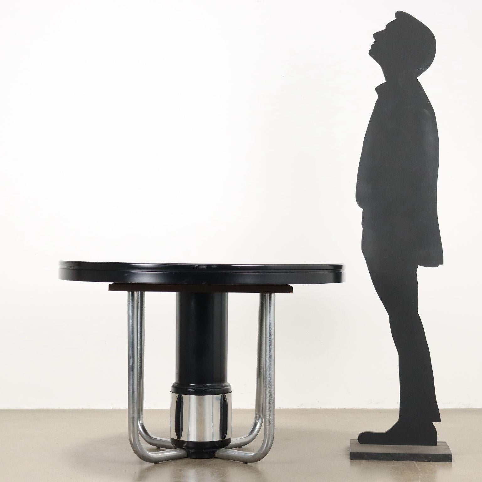 Table extensible au moyen de rallonges dissimulées, en placage de bois exotique, base laquée et métal chromé. 
