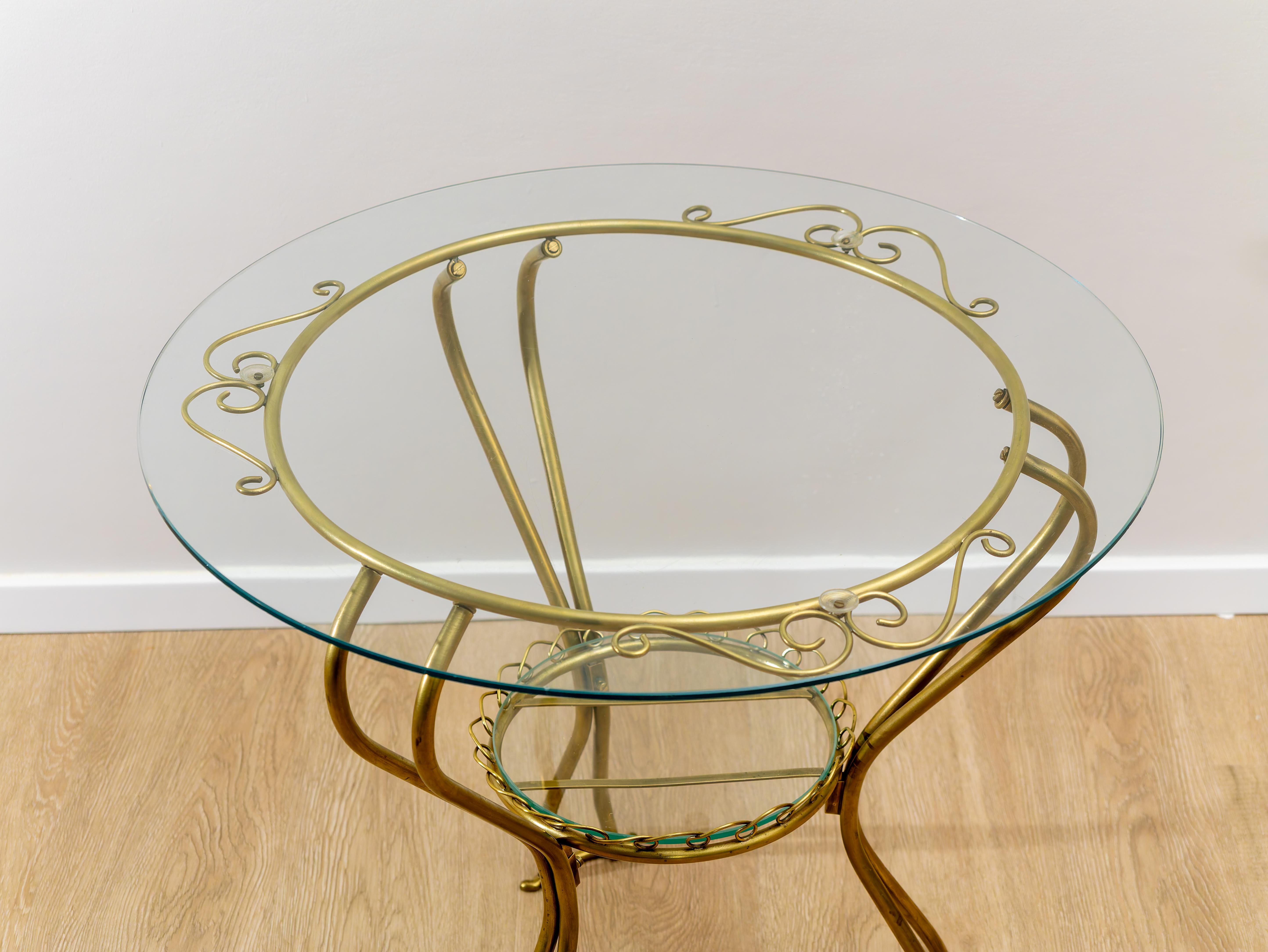Brass round coffee table, Made in Italy, 1950s. 
Elegant round coffee table, Made in Italy, made in the 1950s, with brass frame. Glass is present at both the top and bottom of the object.Condition is excellent, may show slight signs of time due to