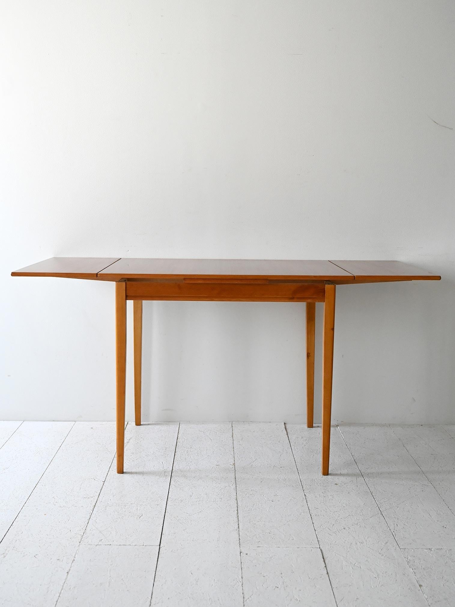 Tavolo anni 60 con struttura in rovere e piano in teak, allungabile con due prolunghe laterali.

Tavolo da pranzo scandinavo originale degli anni 60, con gambe in rovere massello e piano impiallacciato teak. Dotato di due allunghe laterali da 30 cm