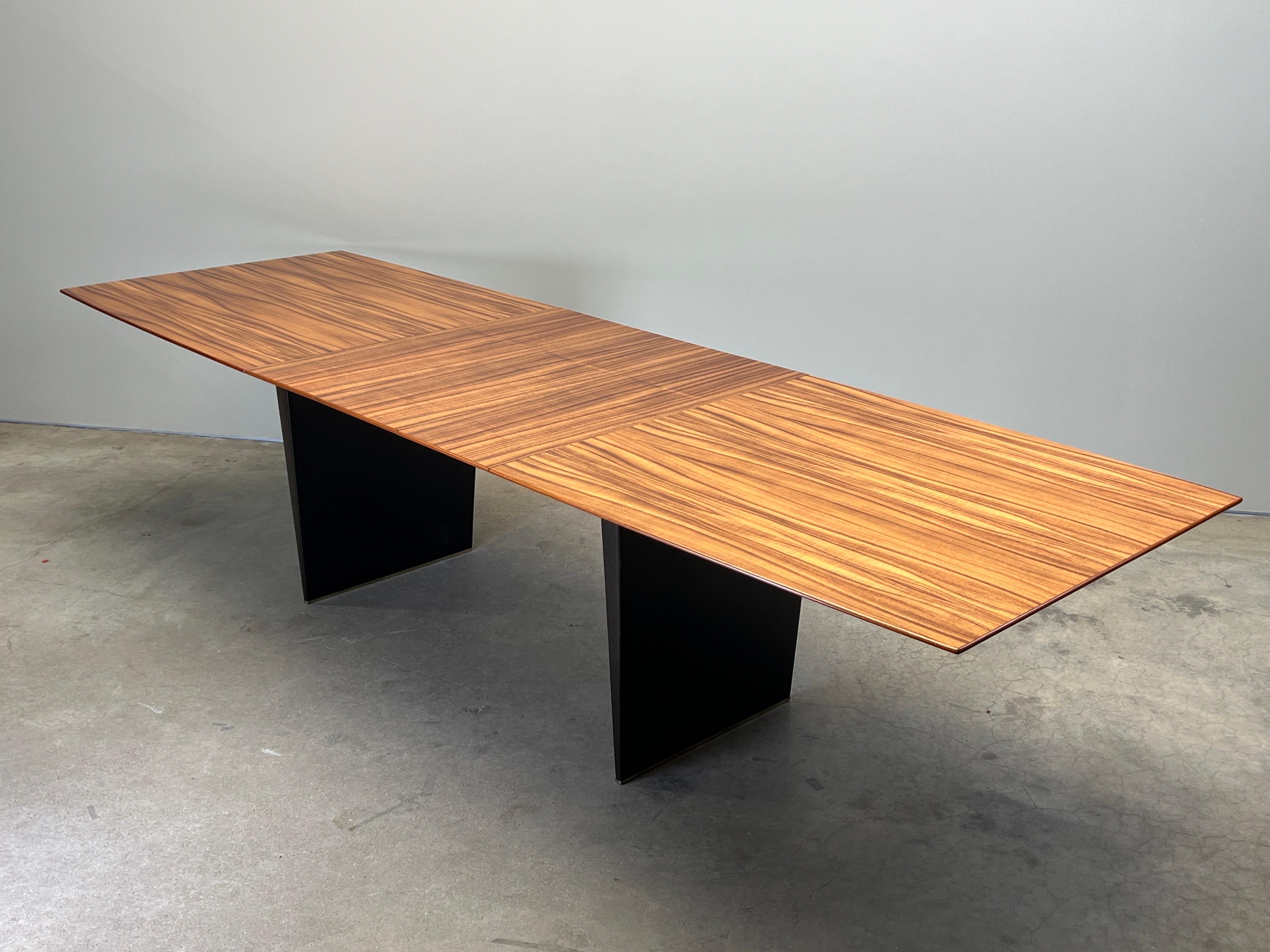 A ten foot dining table designed by Edward Wormley for Dunbar with expressively grained Tawi wood top and mahogany base with brass cleats. The table has three 12'