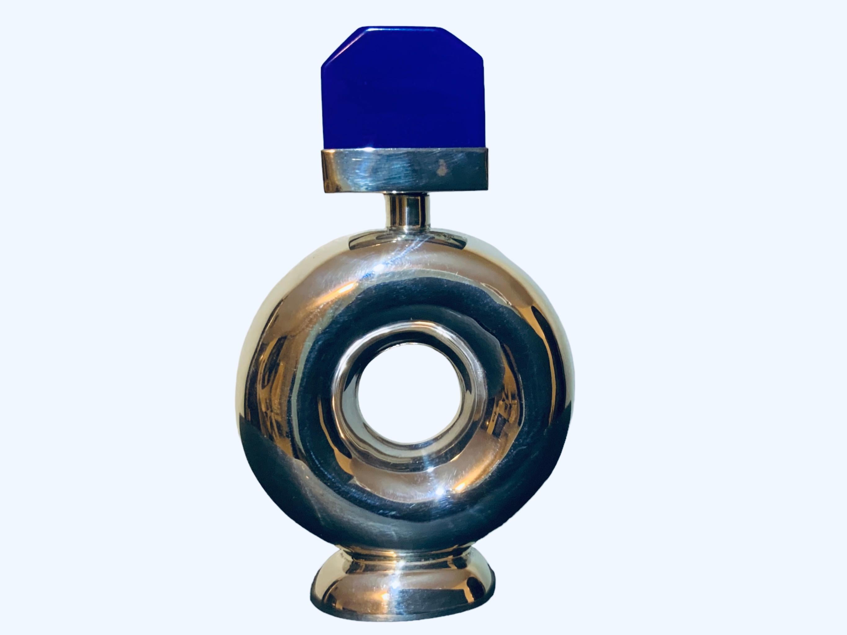 This is a 925 sterling silver and blue stone perfume bottle. It depicts a wide silver ring shaped bottle with an hexagonal shaped cobalt blue stone with sterling silver base serve as a stopper. It is hallmarked 925.