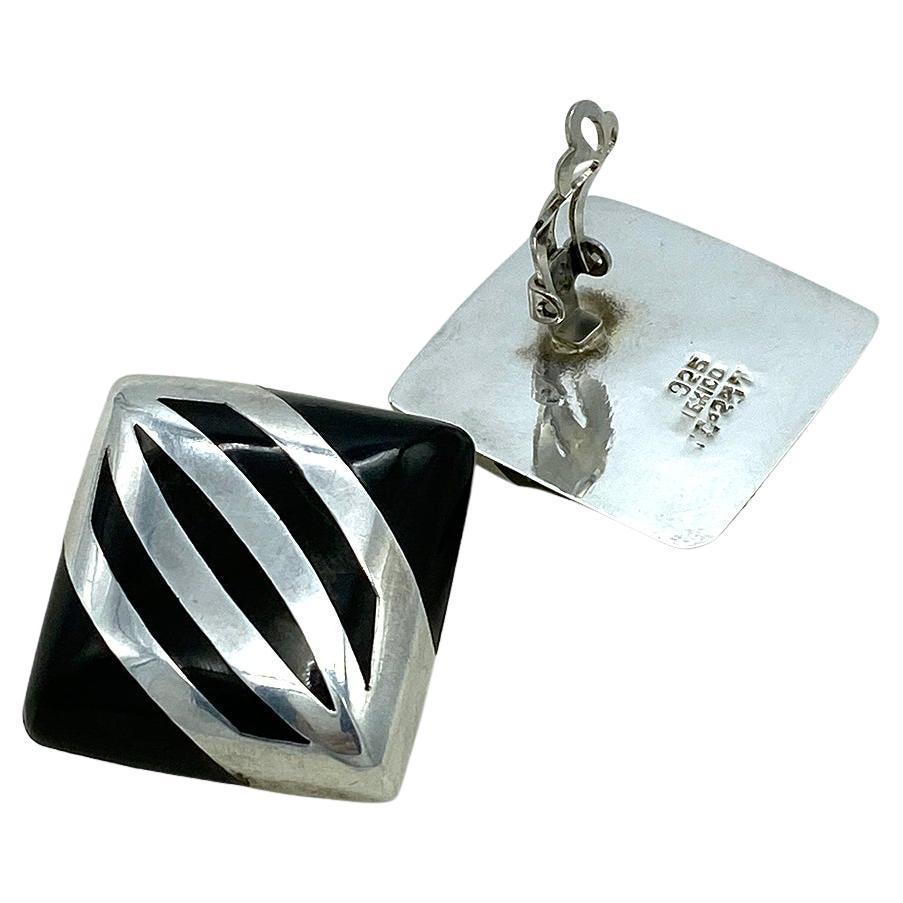 Dies ist ein Paar von Taxco Art Deco Stil Sterling Silber Clip-on Ohrringe. Die großen, quadratisch geformten Ohrringe mit einem auffälligen  Sterlingsilber und schwarzes Emaille-Muster haben eine .925 Mexico TC-237 Marke. 
*T steht für Taxco; C