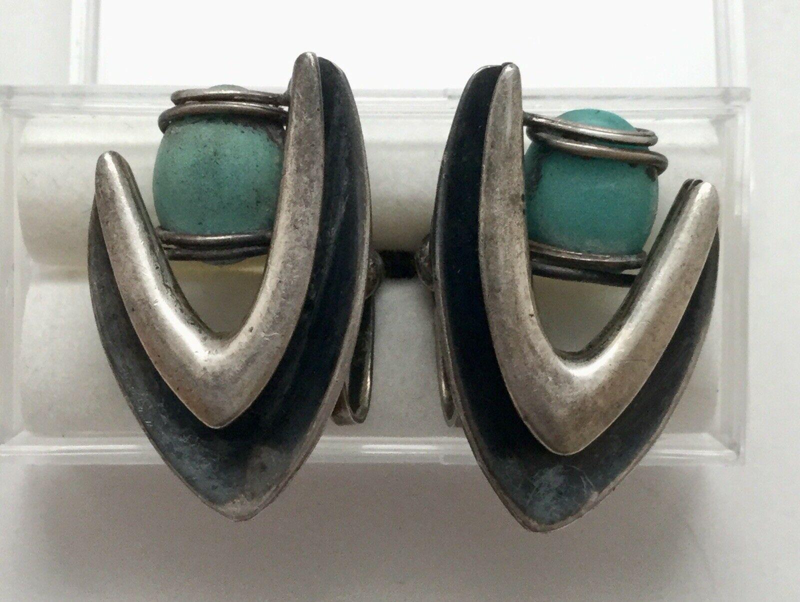 Taxco Mexico sterling silver turquoise boomerang screwback earrings by Jose Luis Flores.

Marked: JLF Taxco Eagle 3, TF-13 Sterling

Measures: 1 1/8