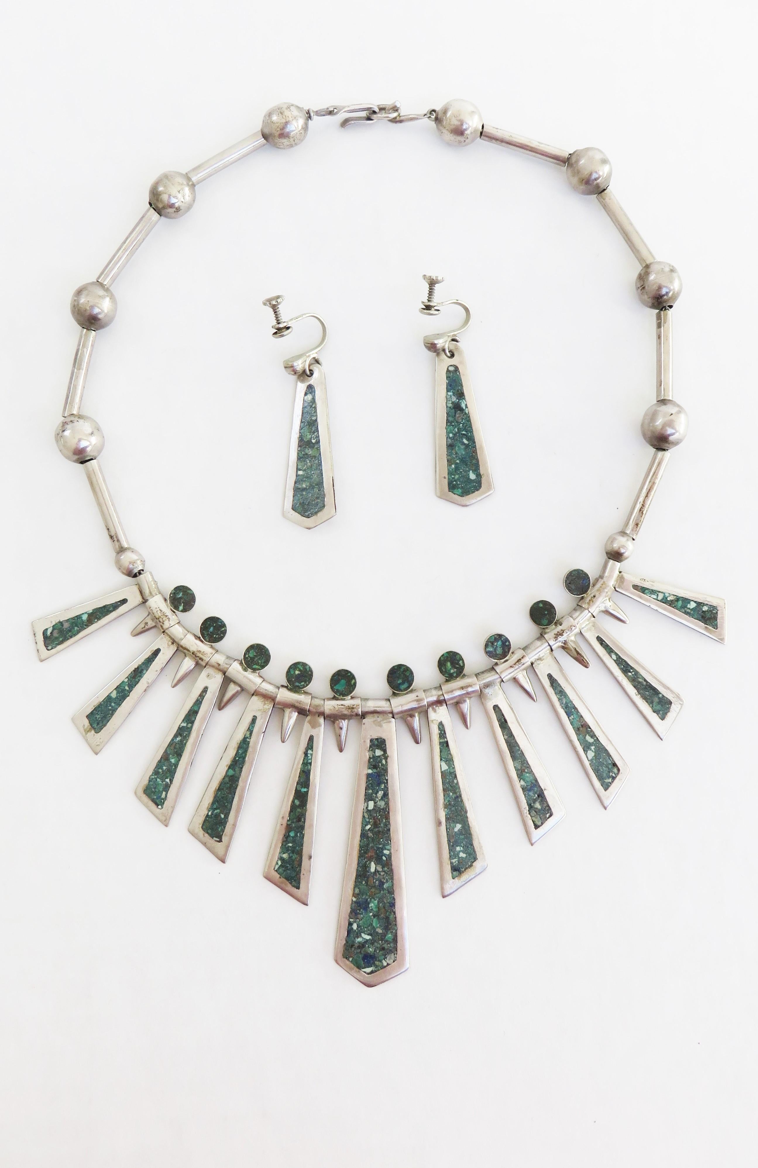 A gorgeous Mexican Sterling silver necklace and earrings set.  The necklace consist of sterling tubes alternating with sterling balls draping in the front with gradated elongated triangular turquoise inlaid pendants from 1-2.25