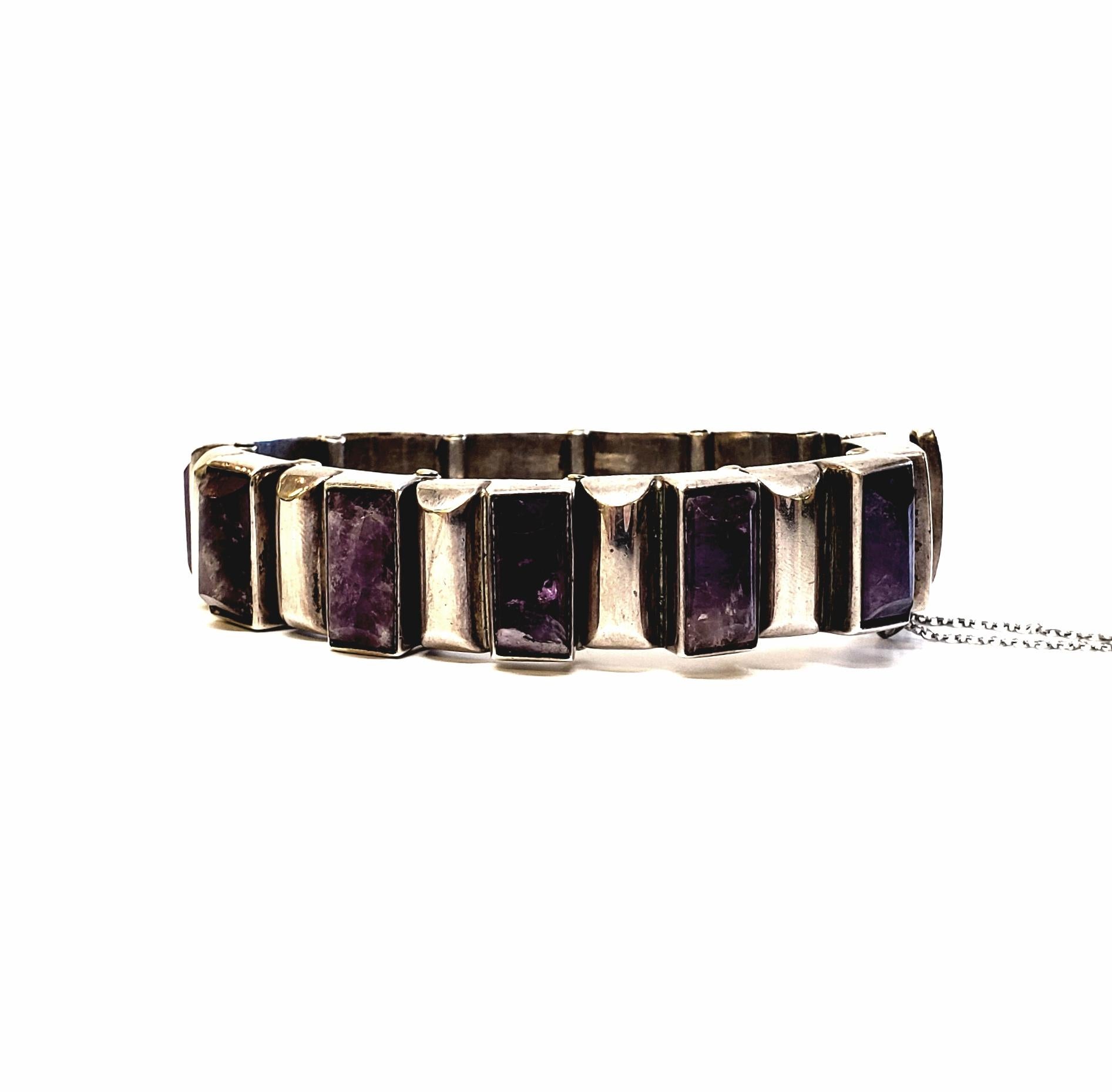 Vintage Taxco, Mexico 970 Silver Amethyst panel link bracelet with safety chain.

Beautiful silver bracelet by renowned master silversmith, Antonio Pineda. The modernist design features articulated rectangular links with bezel set amethyst stones,