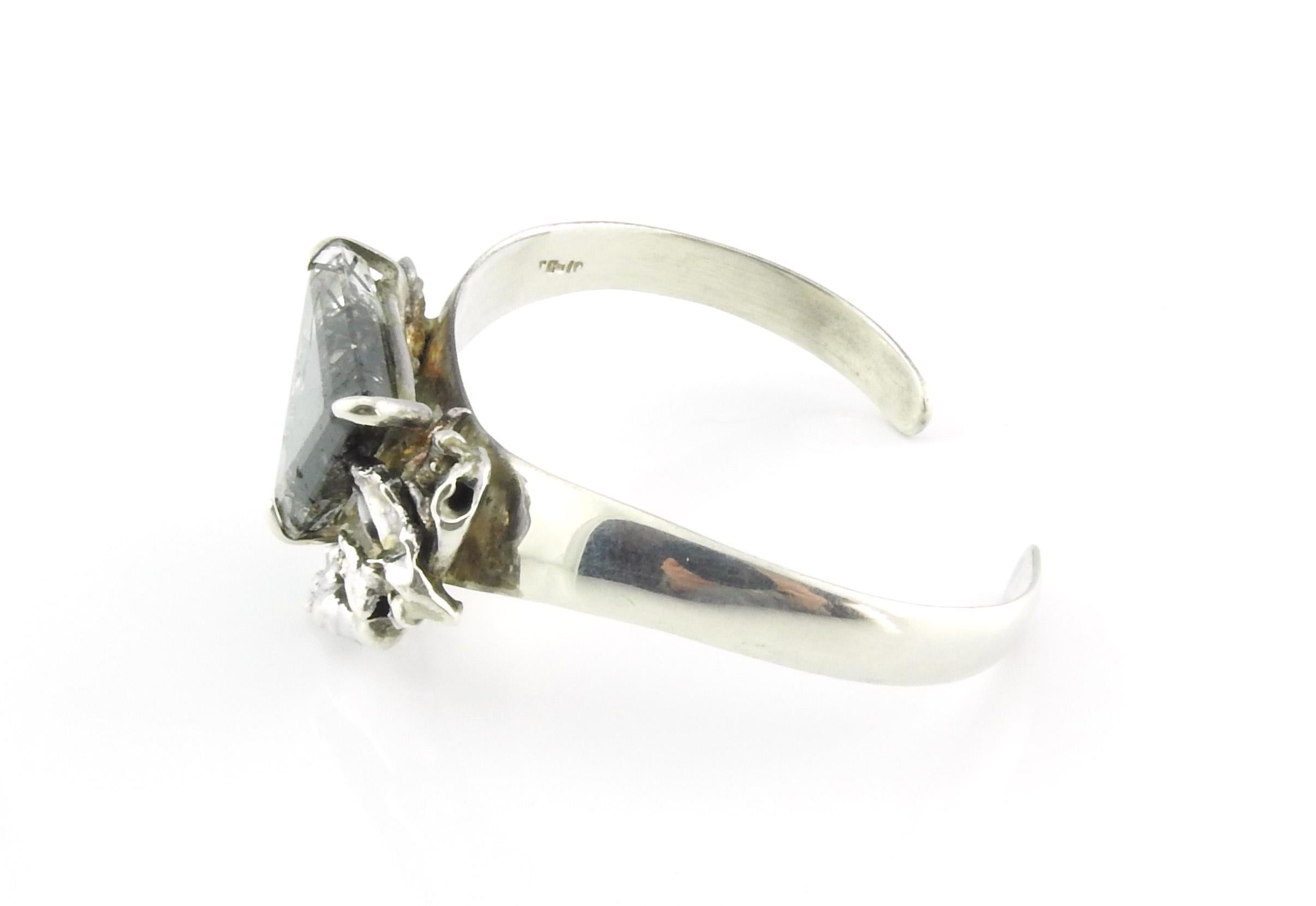 Taxco Mexico sterling silver cuff bracelet with black tourmalinated quartz.

Triangle cut mineral set with prongs.

Marked: 925 MEXICO TC-10.

1980's TC-10 is attributed to Miguel Cisneros.

Quartz measures: 1 1/4