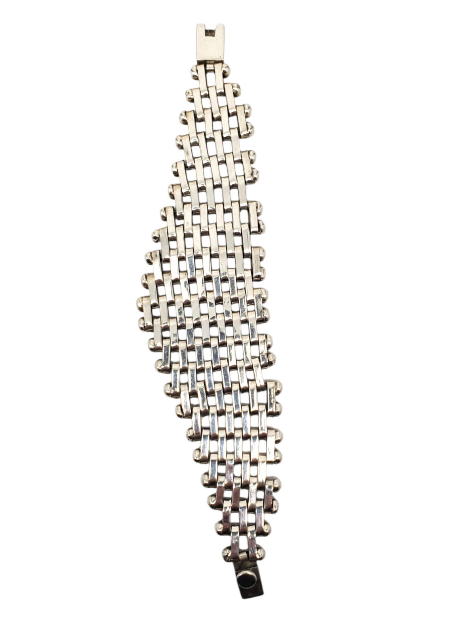 Taxco Mexico Bracciale in argento sterling con intreccio a reticolo -

Questo braccialetto vintage in argento lucido di Taxco Mexico presenta un ampio disegno a reticolo con una maglia a scatola sicura contrassegnata dalla sigla TA-86
